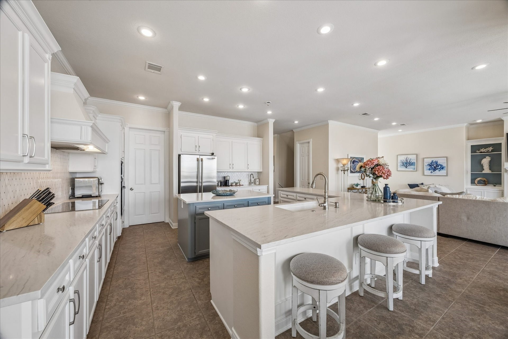 426 Sunset Circle, Tiki Island, TX 77554 Gourmet kitchen featuring quartz countertops, a large center island with ample storage, breakfast bar seating, and dual sinks, including a dedicated prep sink.