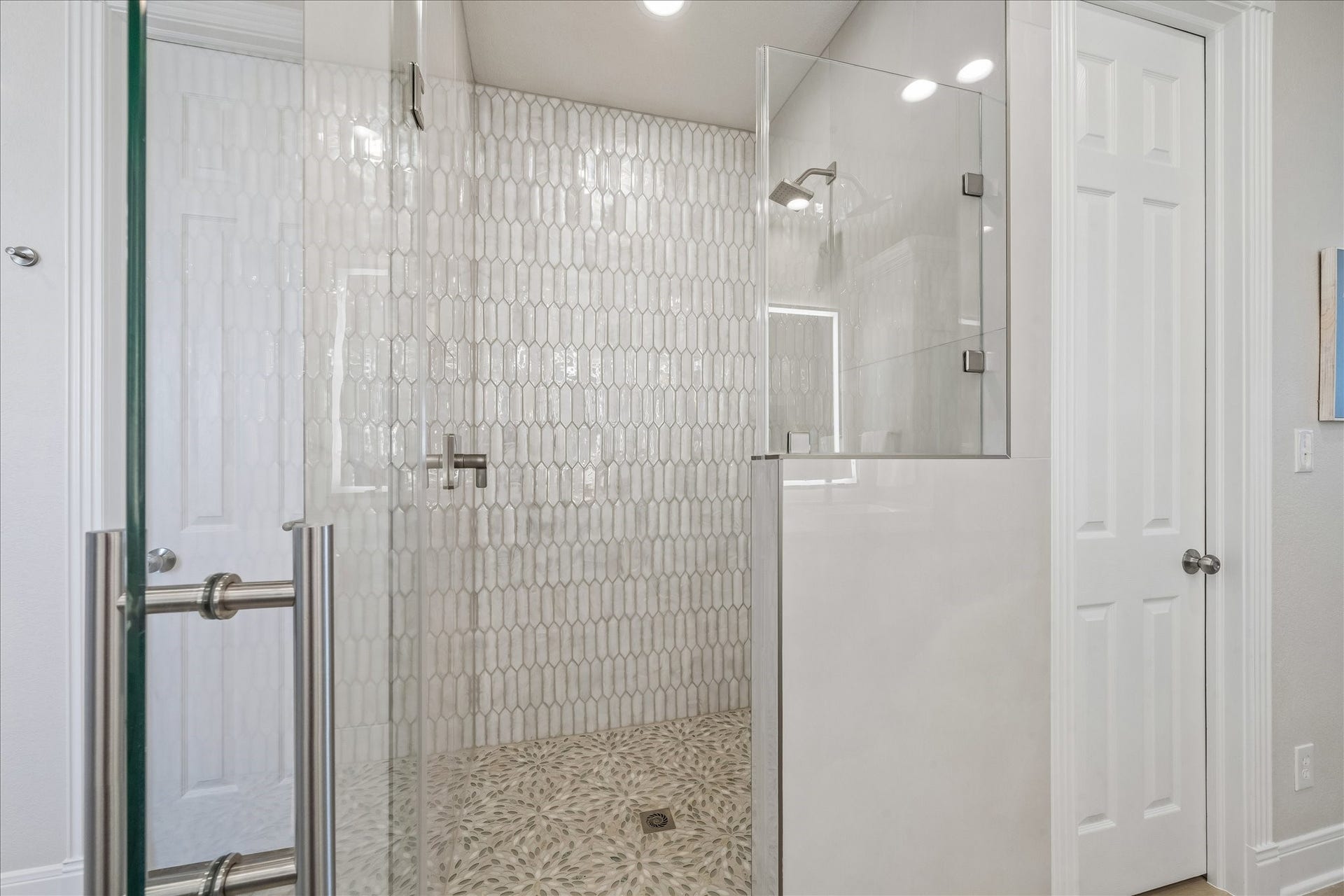 426 Sunset Circle, Tiki Island, TX 77554 Completely remodeled walk-in shower featuring new tile, a generous shower area, and discreet built-in shelving for convenient storage.