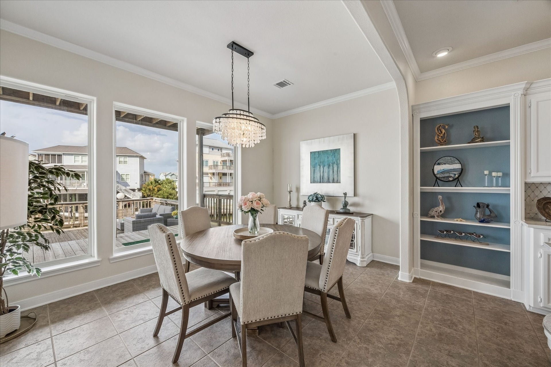 426 Sunset Circle, Tiki Island, TX 77554 Sizable dining area with tile flooring, a striking new chandelier, bookshelves and a wall of windows overlooking the Bay, creates an inviting setting for meals and entertaining with beautiful waterfront views.