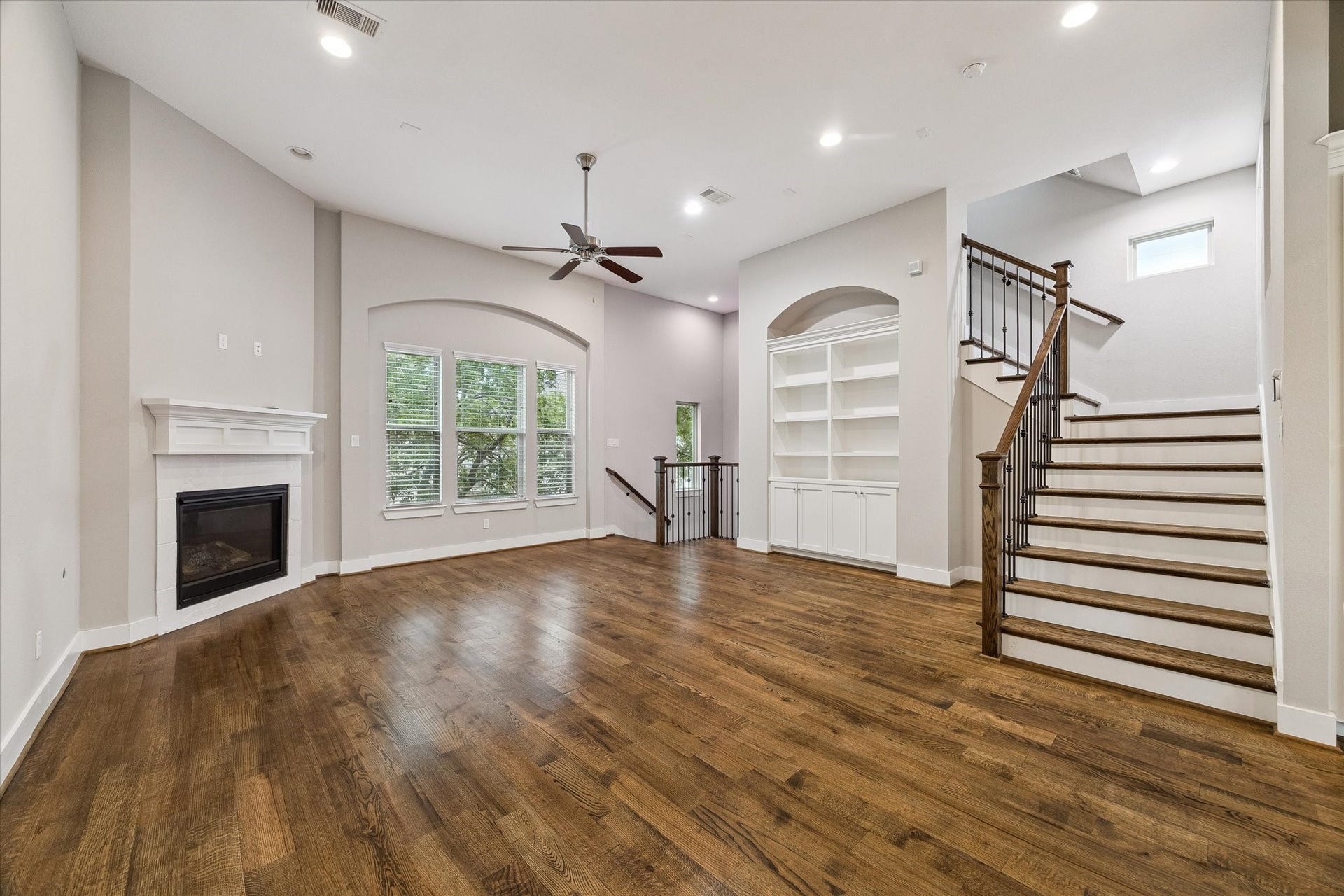 5743 Kiam Street, #F, Houston, TX 77007 Large living room with a gas fireplace, tall ceilings, and built-ins. There is room for a dining table in front of the built-ins.