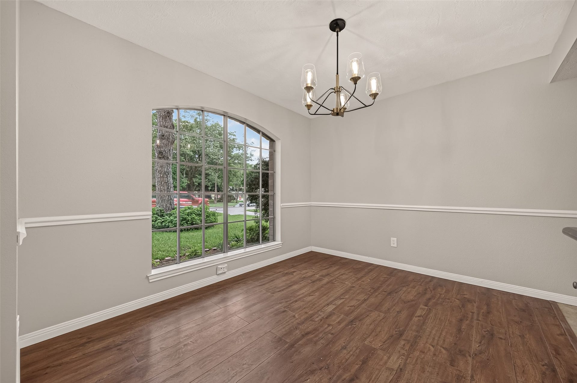 16405 Smith Street, Jersey Village, TX 77040 Natural light pours through the oversized front window, creating a bright and welcoming setting for everyday meals and holiday celebrations alike. A stylish chandelier and chair-rail molding add timeless character, while the spacious layout easily accommodates an expandable dining table for hosting family and friends. The generous wall provides the perfect backdrop for displaying a china cabinet, serving buffet, or treasured family heirlooms that make every gathering feel a little more special.