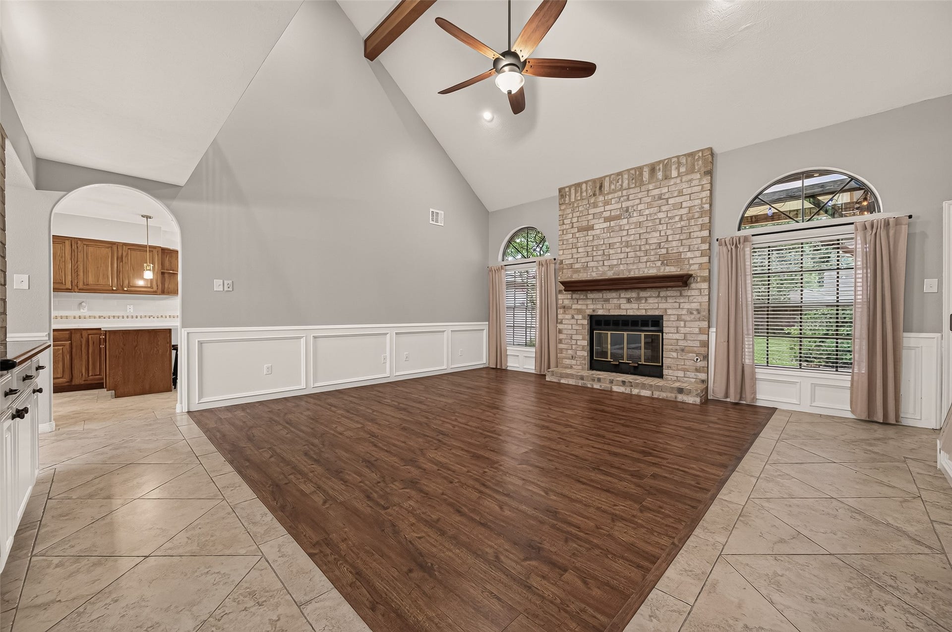 16405 Smith Street, Jersey Village, TX 77040 Every great family room needs a place where everyone naturally gathers, and this one delivers. A floor-to-ceiling brick fireplace with raised hearth and substantial wood mantel creates a warm focal point, while arched windows invite natural light and backyard views inside. Just steps from the kitchen, this comfortable space is ready for everything from quiet evenings at home to lively celebrations with family and friends.