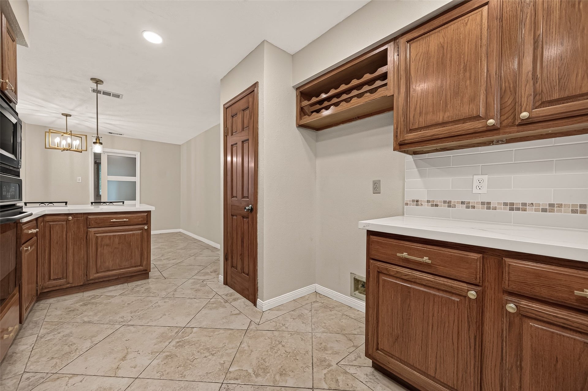 16405 Smith Street, Jersey Village, TX 77040 Organization comes naturally in this well-planned kitchen. The pantry features convenient pull-out trays that keep everyday essentials neatly arranged, while a built-in spice rack on the inside of the pantry door keeps favorite seasonings within easy reach. A built-in wine rack provides attractive bottle storage, and the dedicated refrigerator space easily accommodates either a standard-depth or counter-depth refrigerator.