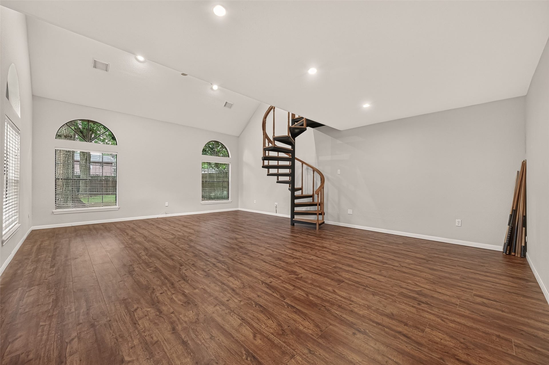 16405 Smith Street, Jersey Village, TX 77040 WOW! The possibilities are nearly endless in this EXPANSIVE Game Room! Soaring ceilings, recessed lighting, wood-look laminate flooring, and oversized arched windows create an impressive space filled with natural light. With room for multiple activity zones, imagine a media area, billiards, home gym, hobby spaceor a combination of your favorites. The spiral staircase adds architectural interest while leading to the loft and home office above.