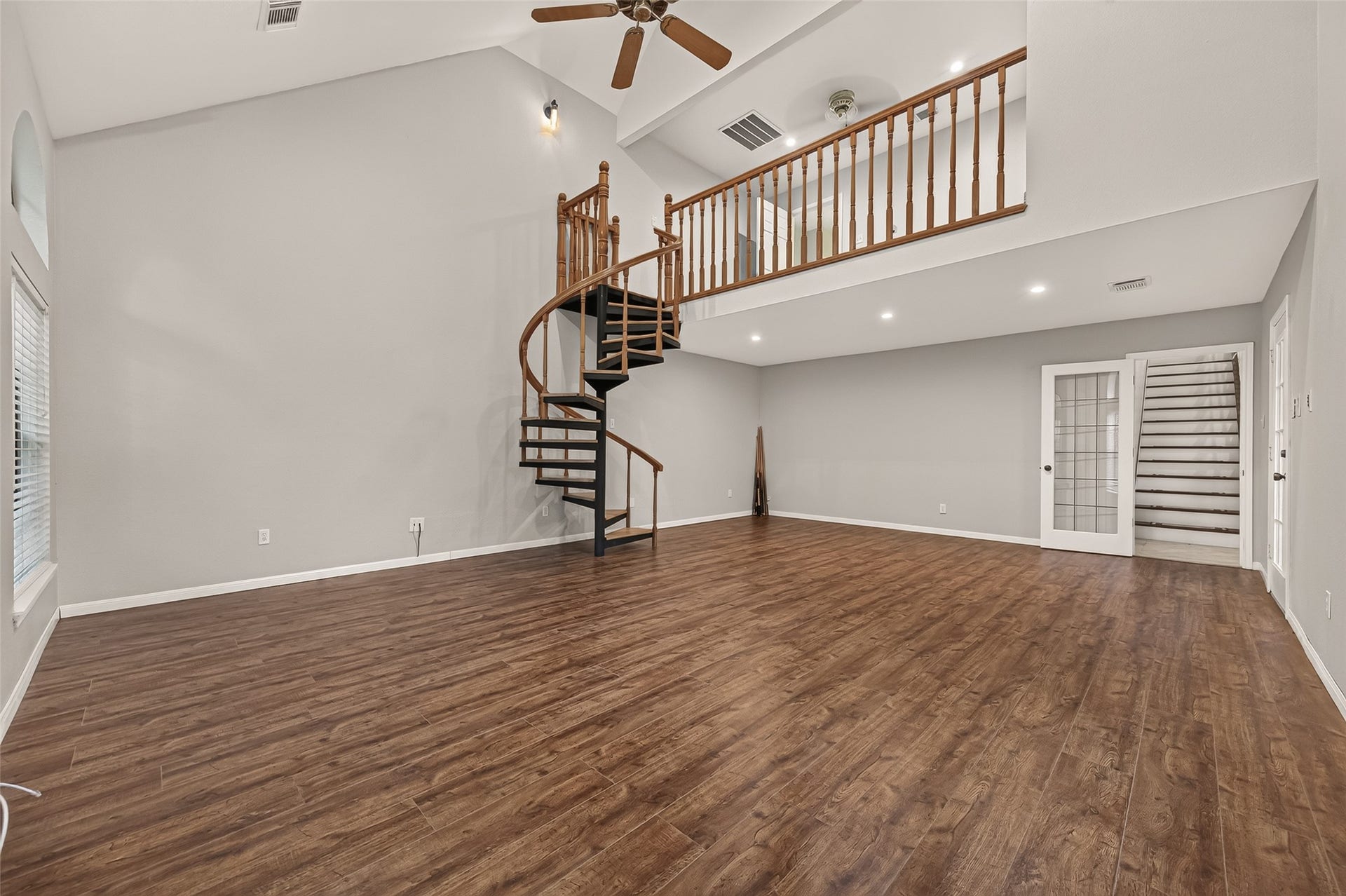 16405 Smith Street, Jersey Village, TX 77040 What a remarkable space! This angle showcases the dramatic spiral staircase and open loft overlooking the Game Room below. The soaring ceiling emphasizes the room's impressive scale, while the loft adds another layer of flexibility upstairs. A dedicated HVAC system with programmable thermostat provides separate climate control for this area of the home.