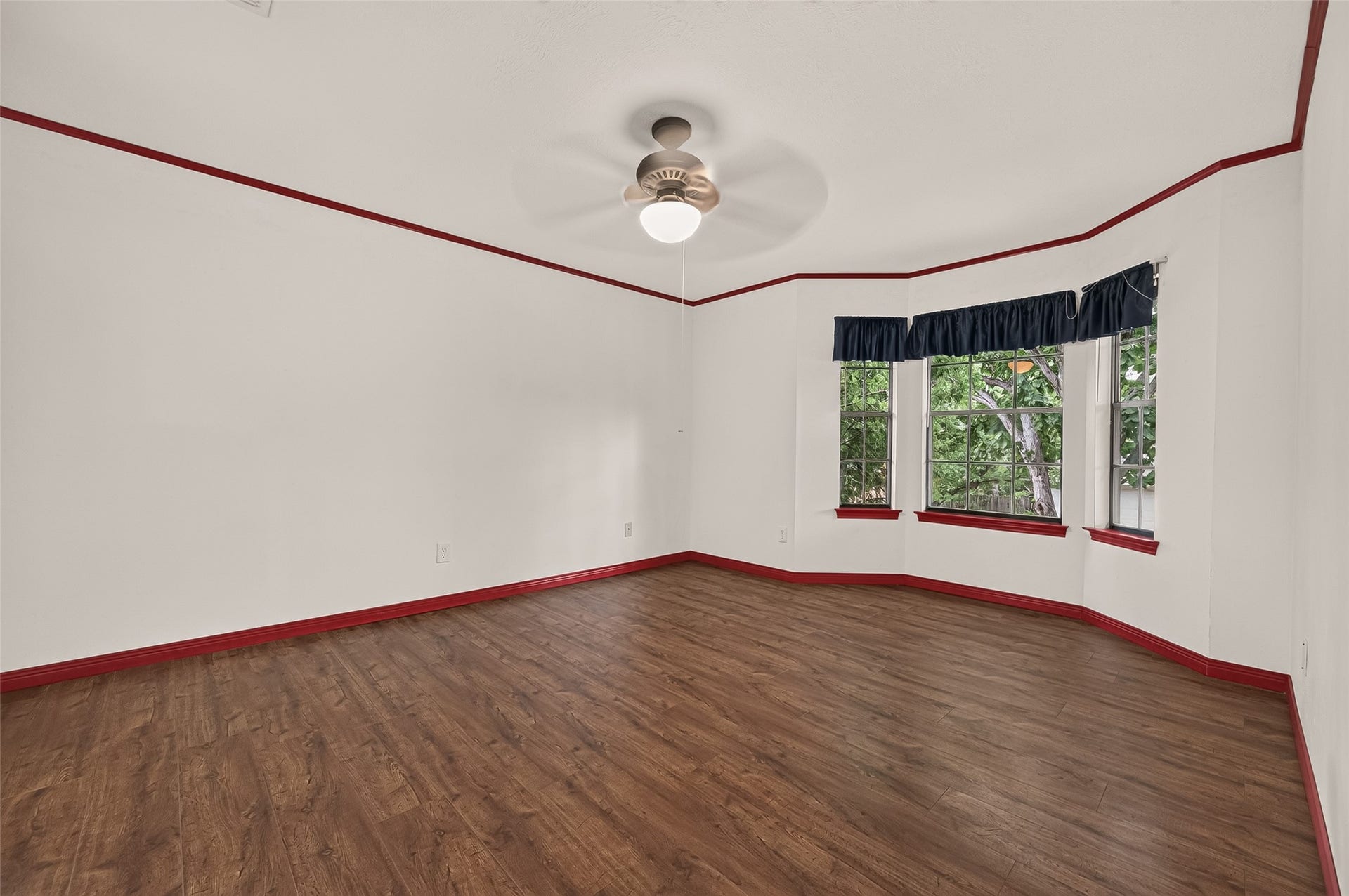 16405 Smith Street, Jersey Village, TX 77040 Bright and welcoming, Bedroom #3 offers generous proportions and plenty of wall space for a king-size bed, dressers, bookshelves, and accent furniture. A beautiful bay window fills the room with natural light while creating the perfect nook for a reading chair, desk, or favorite houseplant. Wood-look laminate flooring, a ceiling fan, and picturesque views of the mature treetops add to the appeal. A lighted walk-in closet and direct access to private Bath #3 complete this comfortable, well-designed space.