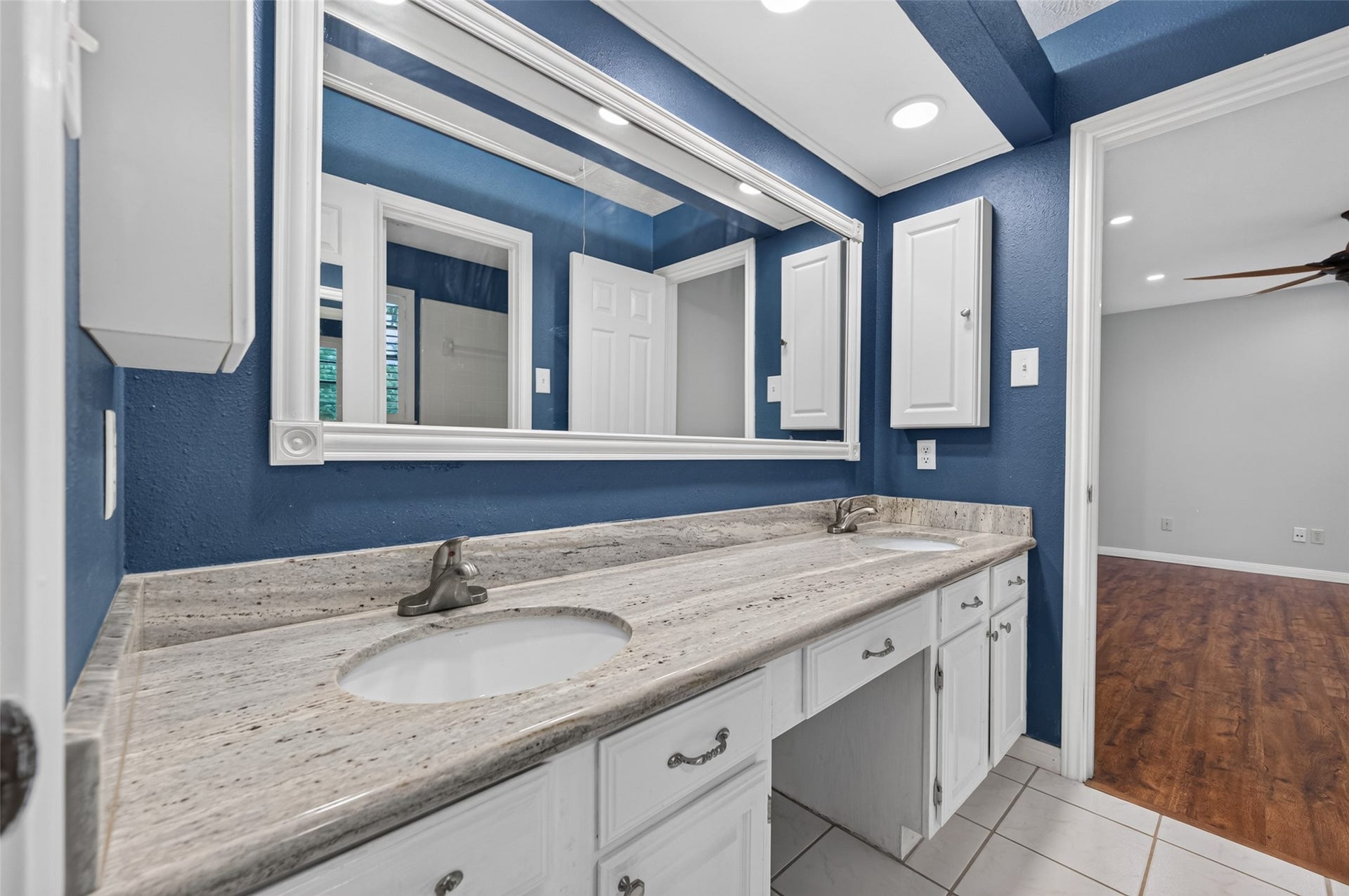 16405 Smith Street, Jersey Village, TX 77040 Designed with busy households in mind, this Jack-and-Jill bath offers a practical layout that easily accommodates multiple family members during the morning rush. The granite-topped vanity features dual sinks, a convenient makeup knee space, and medicine cabinets at each end for added storage. A separate bathing area with a tub/shower combination, private commode, and linen closet allows to shower while another uses the vanity, making hectic mornings just a little easier.