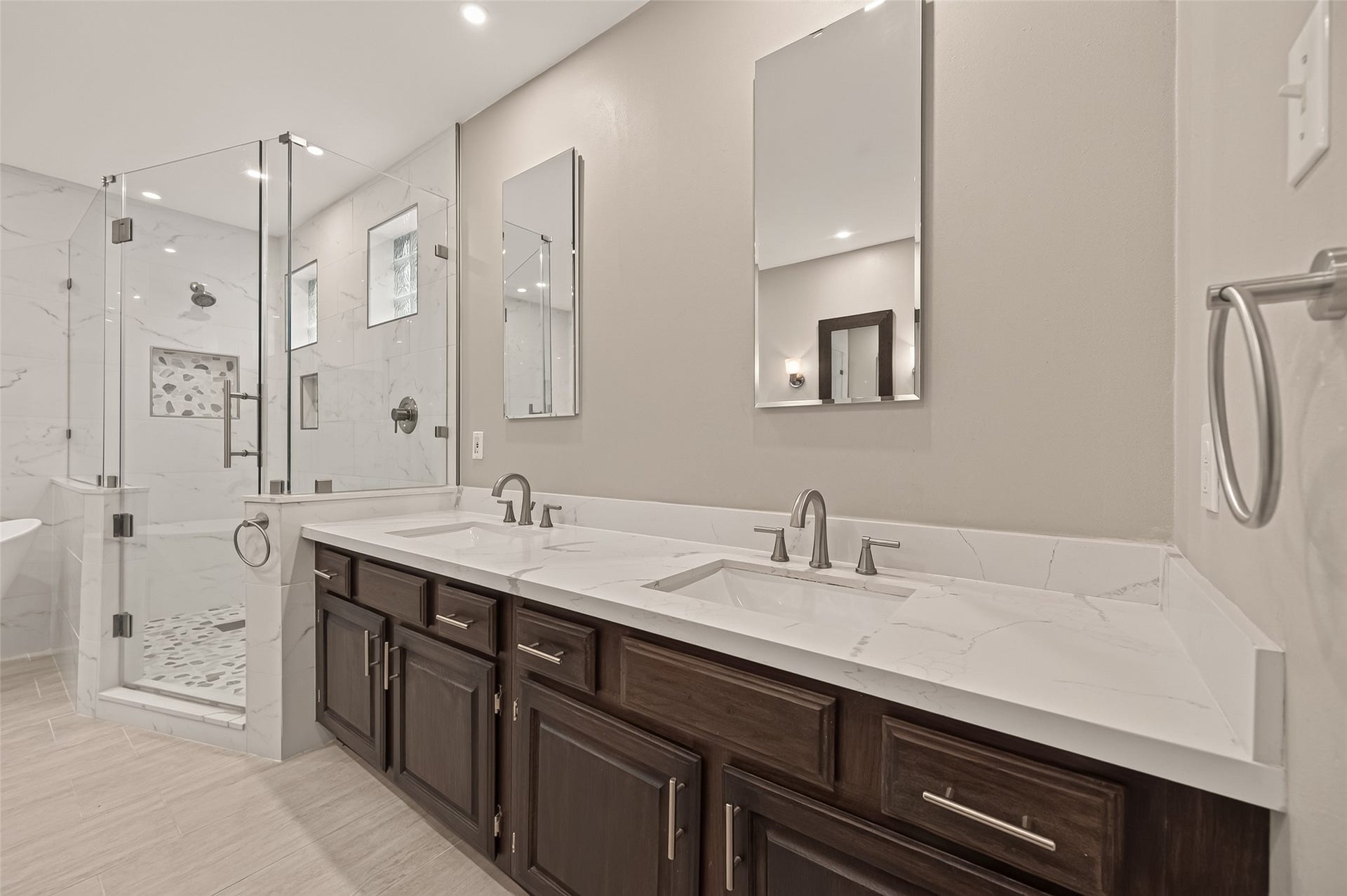 16405 Smith Street, Jersey Village, TX 77040 Completely remodeled in 2021, the luxurious primary bath blends clean lines with spa-inspired finishes. Quartz countertops, rectangular undermount sinks, mirrored medicine cabinets, and recessed lighting create a bright, functional space, while the expansive dual vanity provides generous counter space for busy mornings.