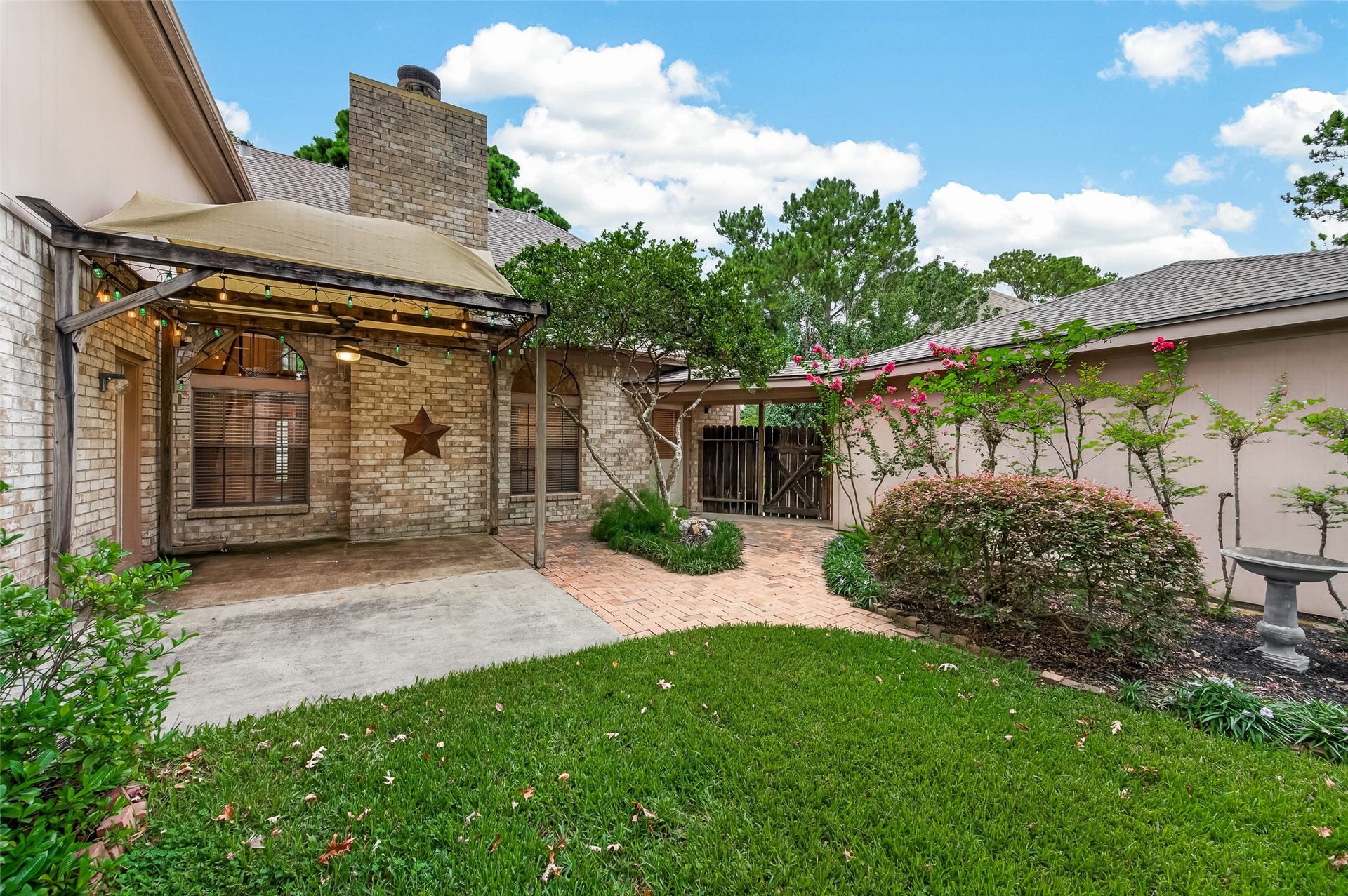 16405 Smith Street, Jersey Village, TX 77040 Step outside to a beautifully landscaped backyard where brick walkways, colorful crepe myrtles, and mature shade trees create a peaceful outdoor retreat. The covered pergola patio invites you to relax, entertain, and enjoy the outdoors year-round.