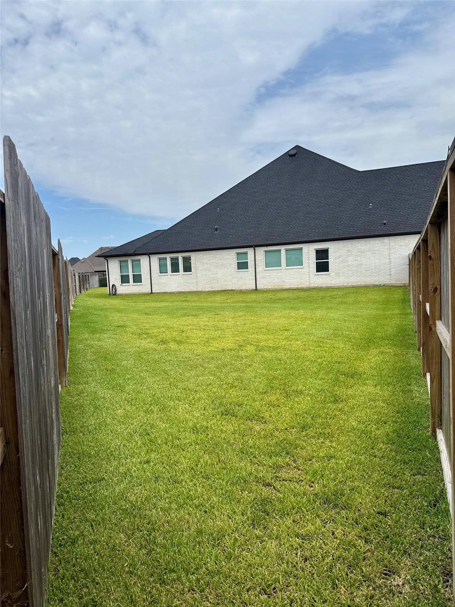 9911 Deep Water Drive, Missouri City, TX 77459 Expansive backyard with lush green lawn, perfect for outdoor activities and relaxation, ample space for a pool and enclosed by a wooden privacy fence.