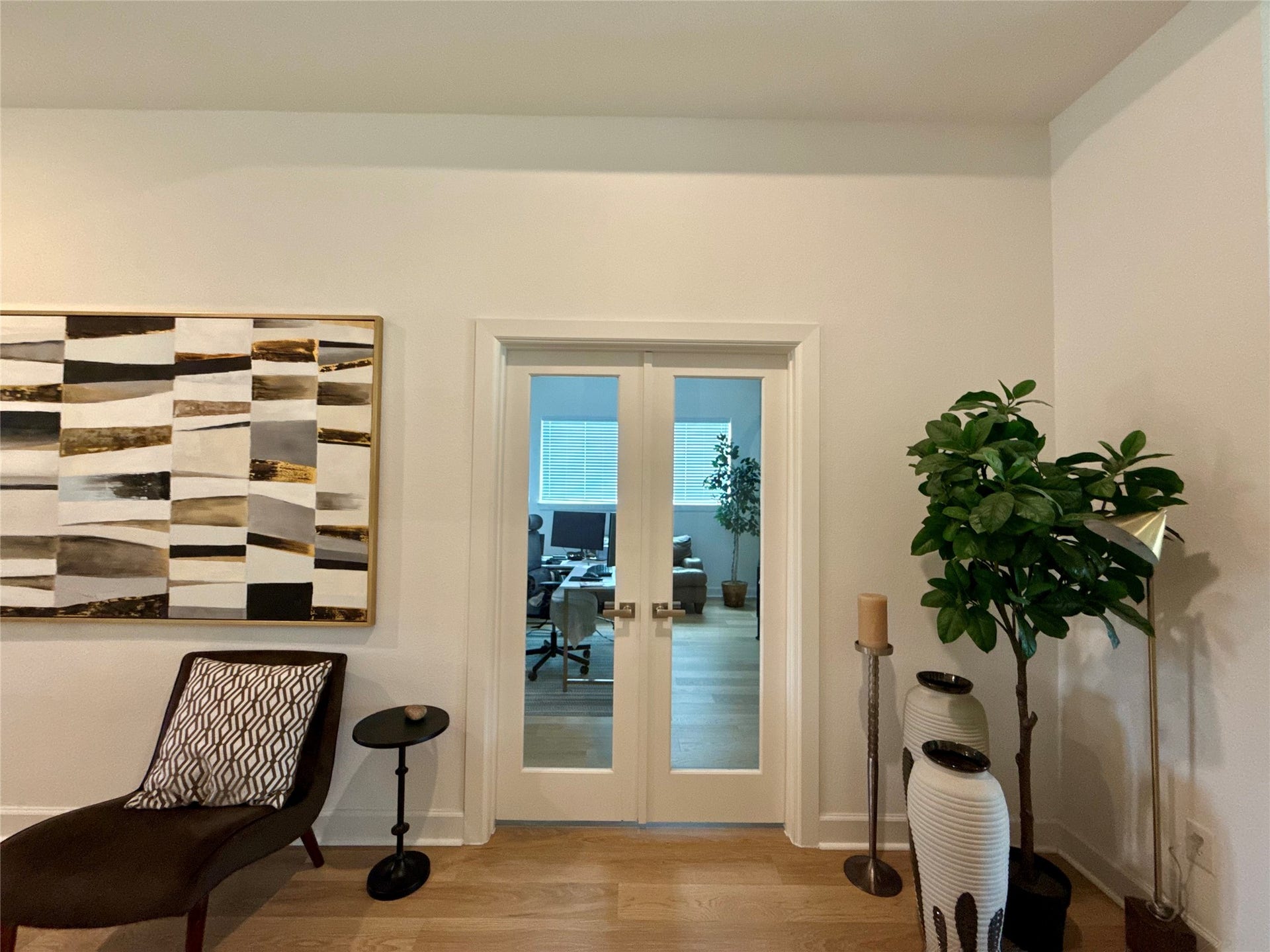 9911 Deep Water Drive, Missouri City, TX 77459 Elegant interior featuring glass double doors leading to home office complemented by modern decor and a large abstract painting.