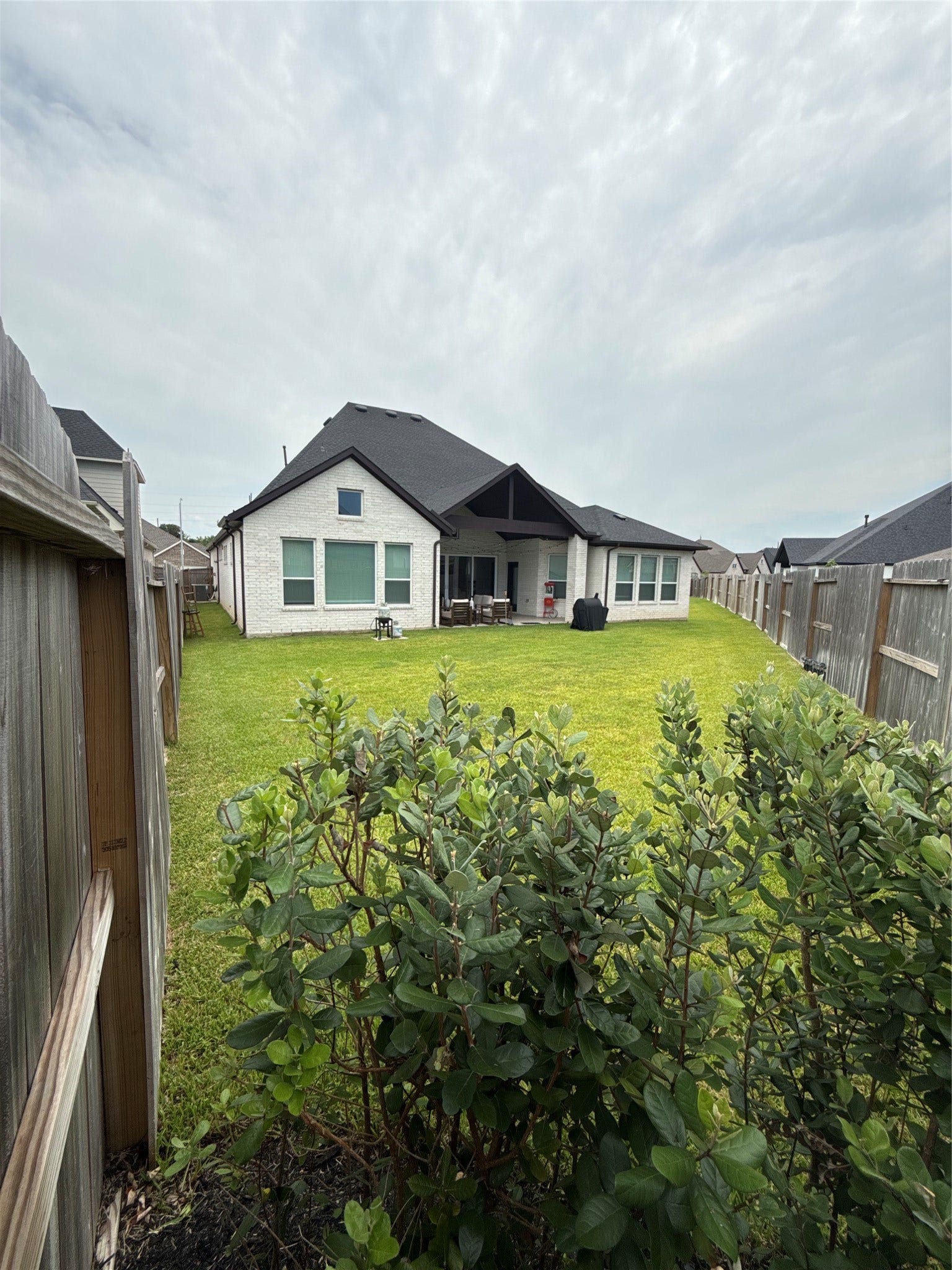9911 Deep Water Drive, Missouri City, TX 77459 Expansive backyard with lush green lawn, perfect for outdoor activities, featuring a modern home with a spacious covered patio ideal for relaxation and entertaining.