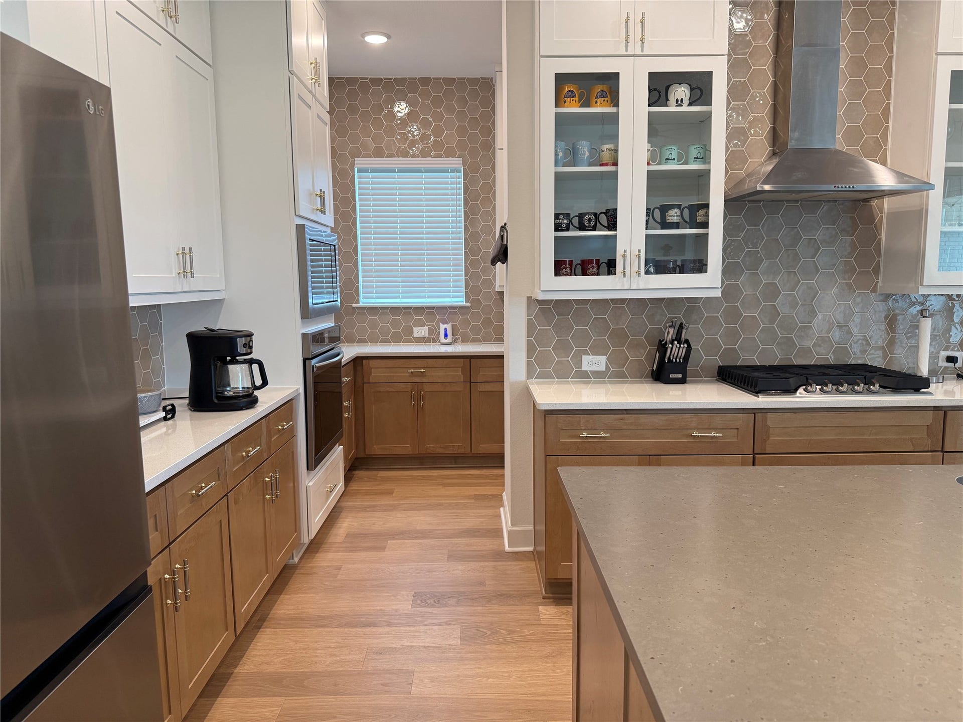 9911 Deep Water Drive, Missouri City, TX 77459 Modern kitchen with sleek stainless steel appliances, elegant quartz countertops, and stylish honeycomb tile backsplash to ceiling!