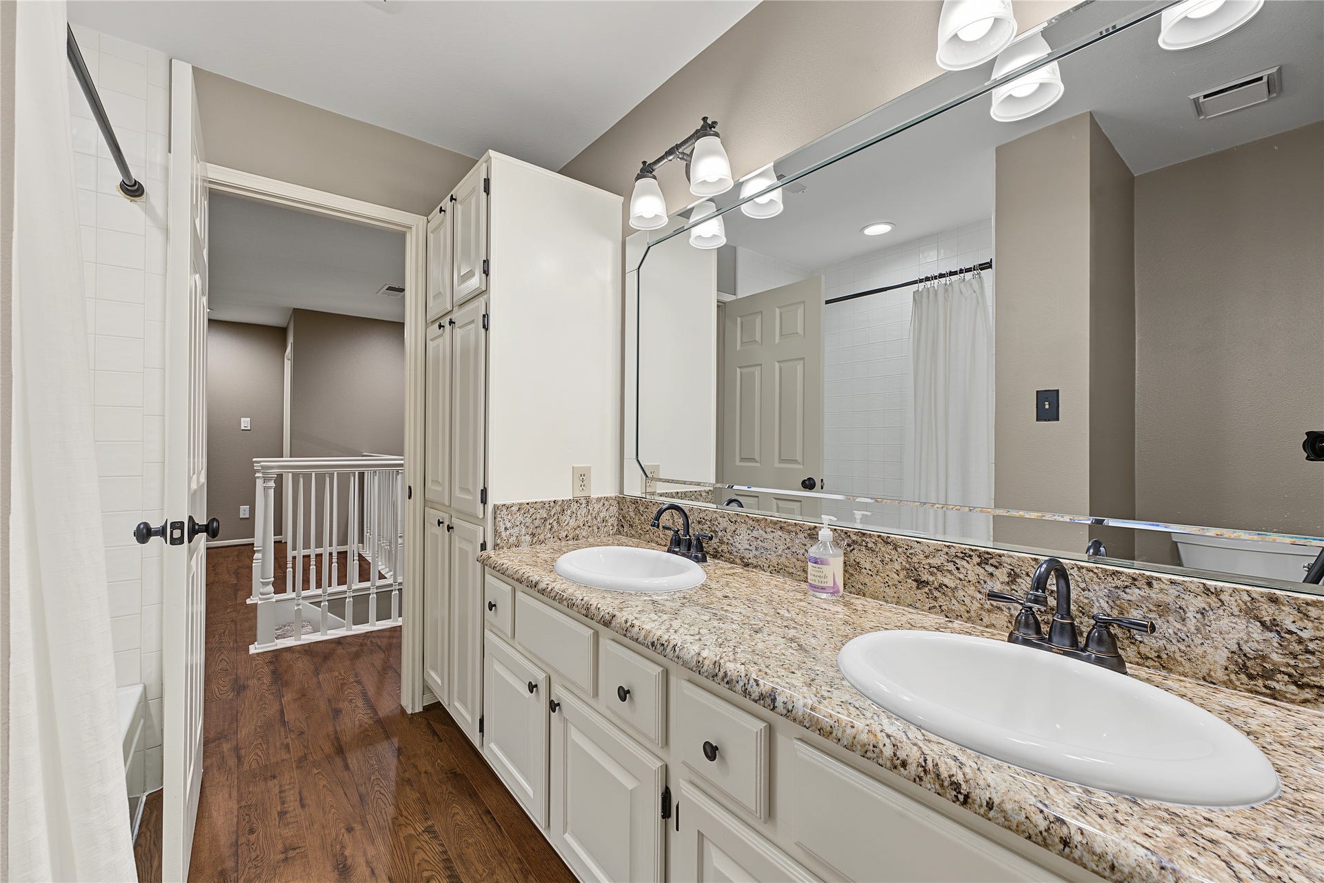 5 Otter Pond Place, The Woodlands, TX 77381 Upstairs full bathroom featuring a convenient double-sink vanity and ample cabinetry.