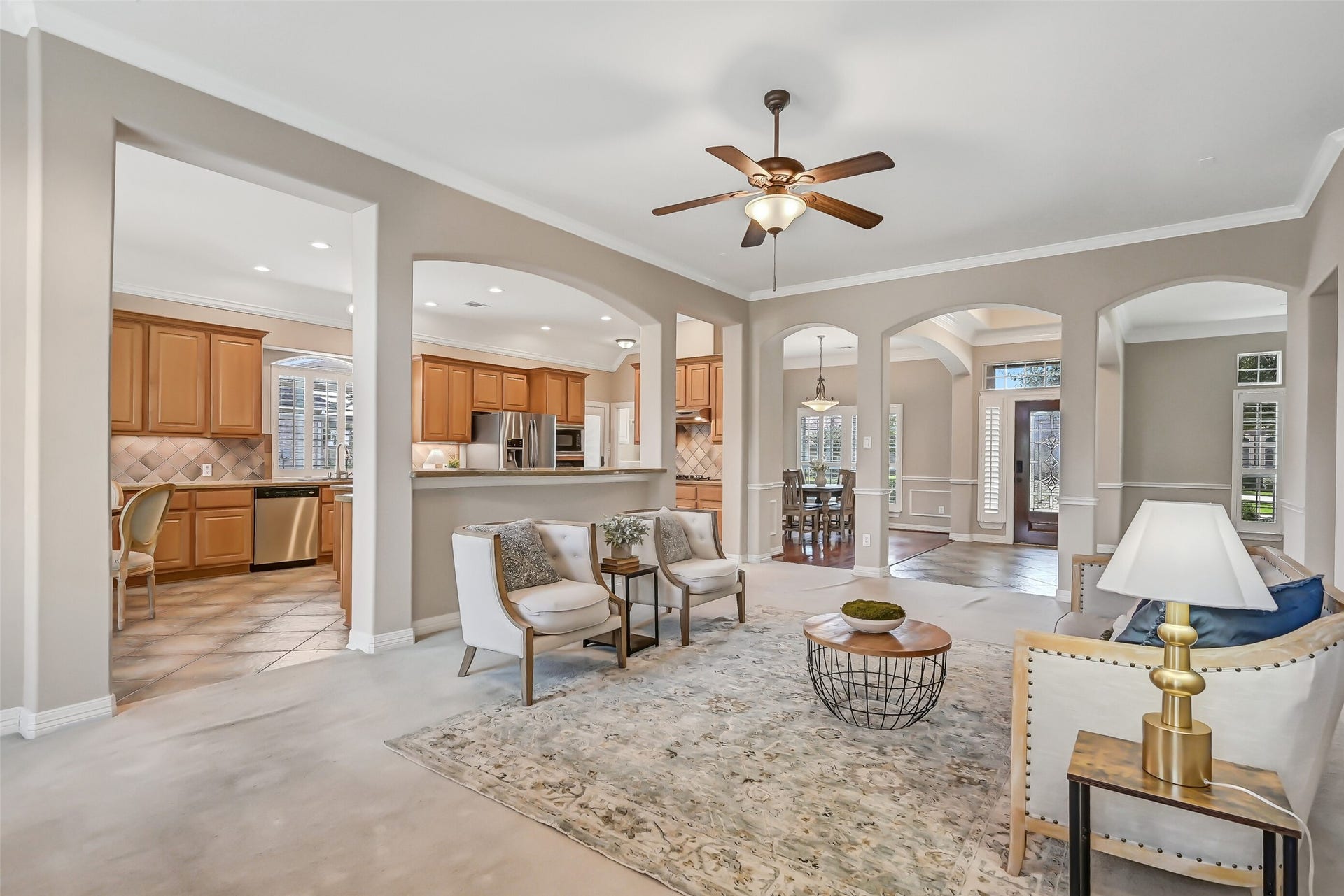1813 Sandy Lake Drive, Friendswood, TX 77546 Looking back toward the entry reveals just how open and connected this single-story floor plan feels. Multiple arched openings provide easy flow between the family room, kitchen, dining room & front flex space, while 10' ceilings and crown molding continue throughout.