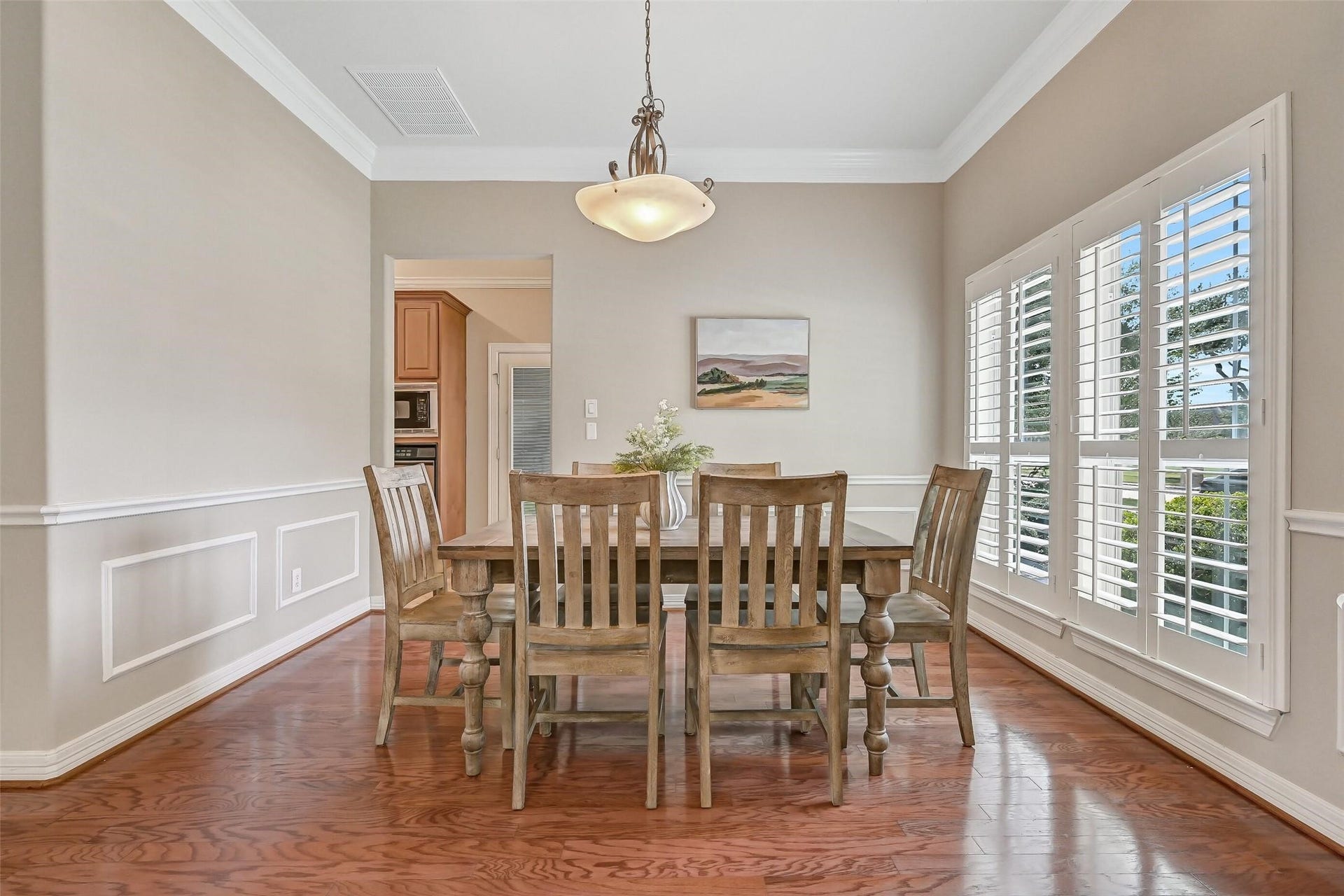 1813 Sandy Lake Drive, Friendswood, TX 77546 Just off the entry, the spacious dining room showcases rich wood flooring, crown molding, chair rail with picture-frame molding & a wall of plantation-shuttered windows that fills the room with natural light.