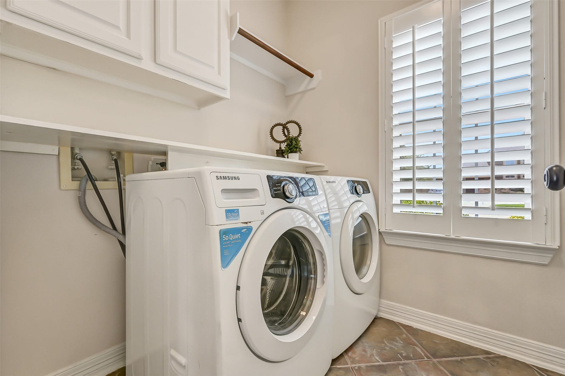 1813 Sandy Lake Drive, Friendswood, TX 77546 Conveniently located just beyond the kitchen, the dedicated utility room offers built-in upper cabinetry, a hanging rod & additional shelving for everyday organization. A plantation-shuttered window brings natural light into this practical workspace.