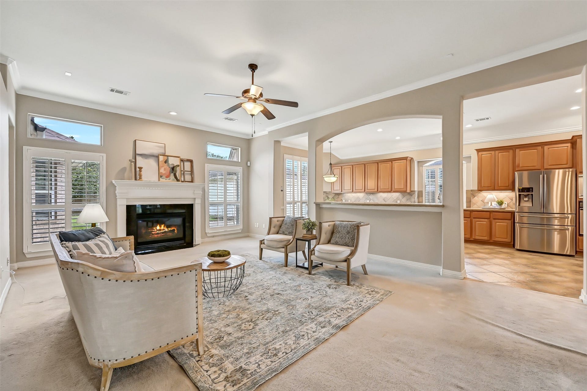 1813 Sandy Lake Drive, Friendswood, TX 77546 Continue into the generous family room, where a gas-log fireplace creates the focal point and tall plantation-shuttered windows bring in abundant natural light. Wide arched openings connect the room to the kitchen while maintaining definition between the spaces.