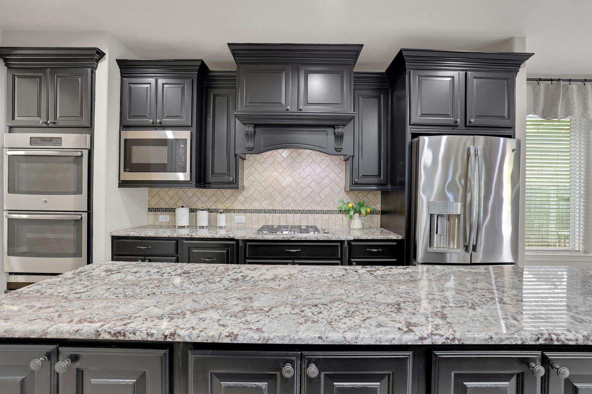 The kitchen features double ovens and ample prep space for the chef in the family