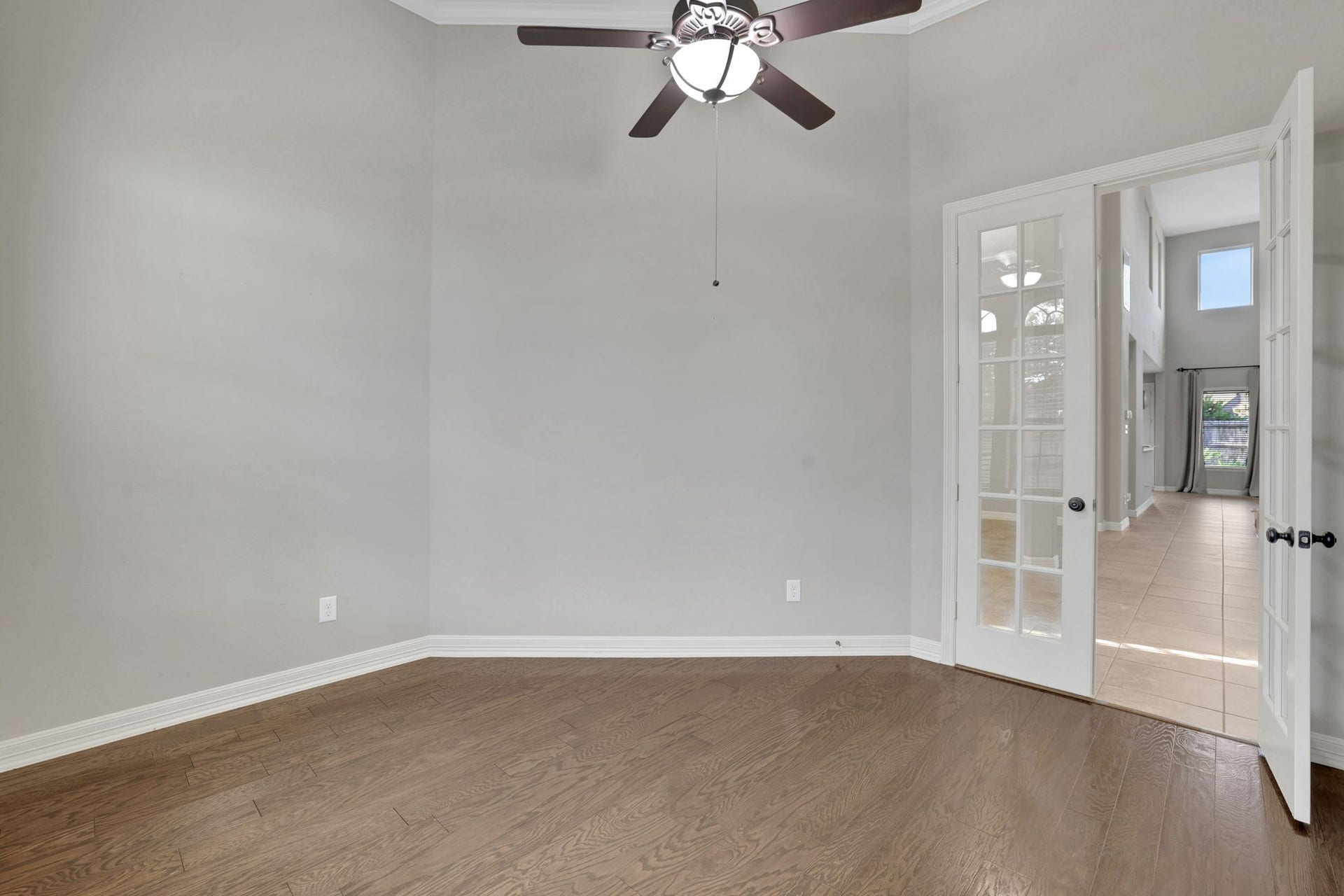 The office has wood floors and French doors for privacy