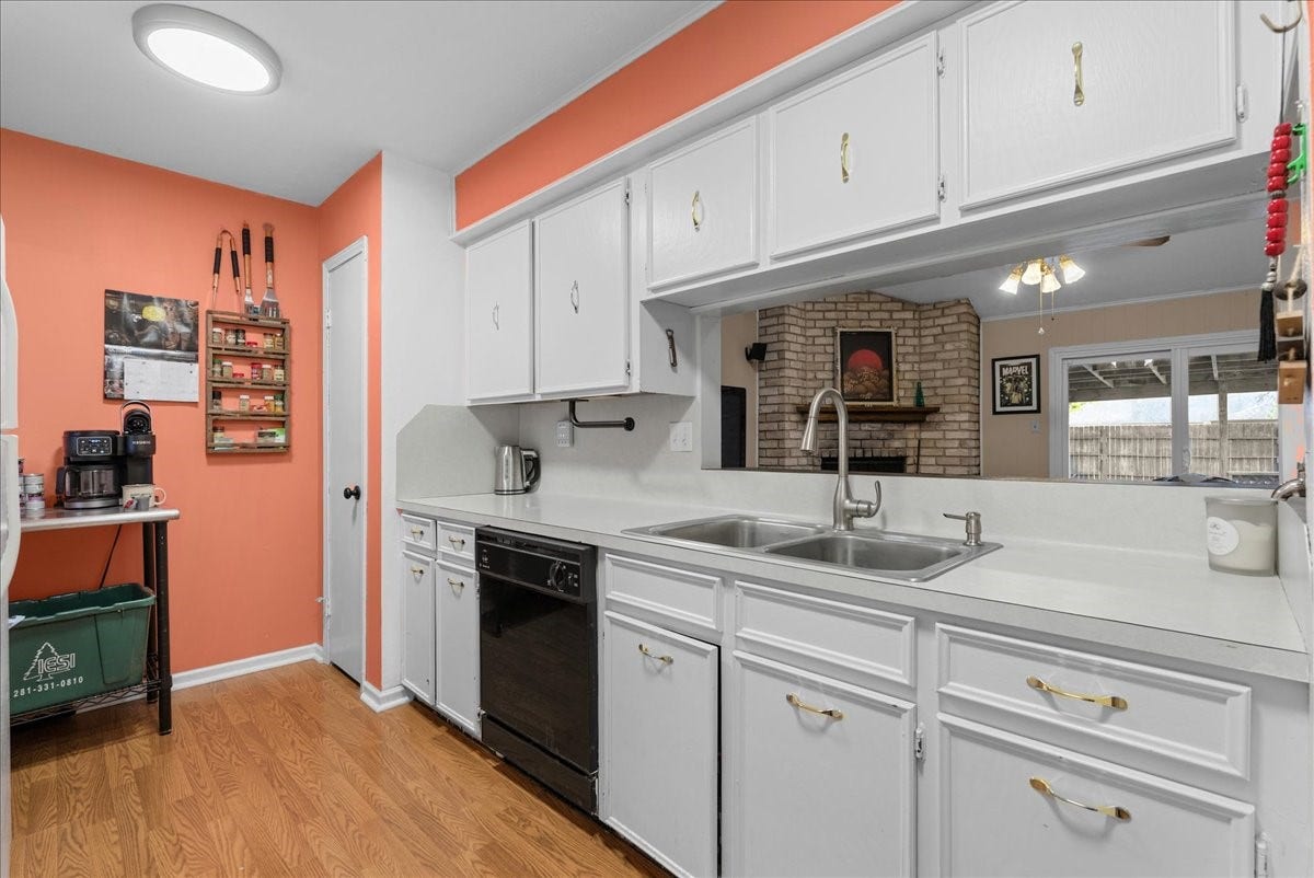 214 Oakwood Street, League City, TX 77573 Kitchen features a double-basin sink, dishwasher, and pass-through overlooking the living room.
