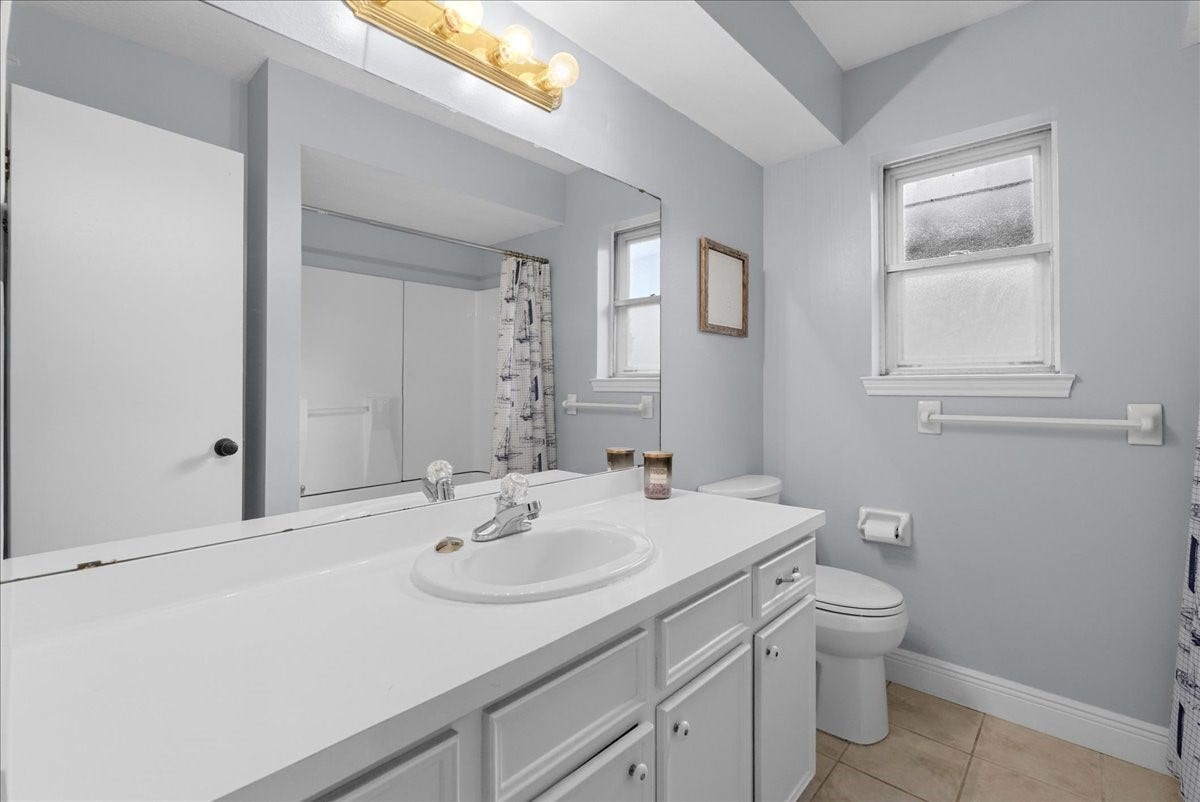 214 Oakwood Street, League City, TX 77573 Secondary bathroom with white vanity cabinetry, generous counter space, and tub/shower combination.