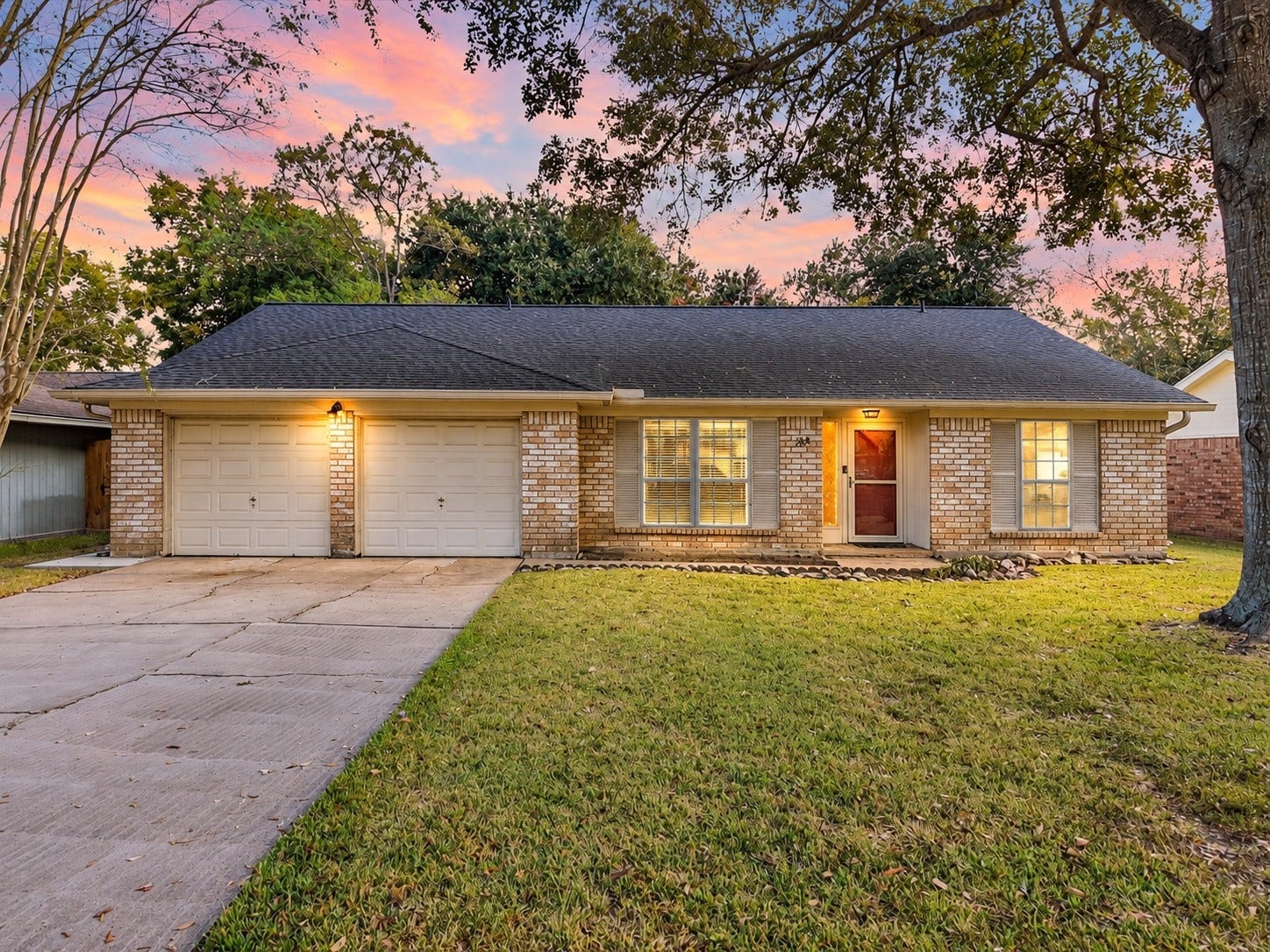 214 Oakwood Street, League City, TX 77573 Twilight view highlighting the home's traditional brick exterior and welcoming evening appearance.