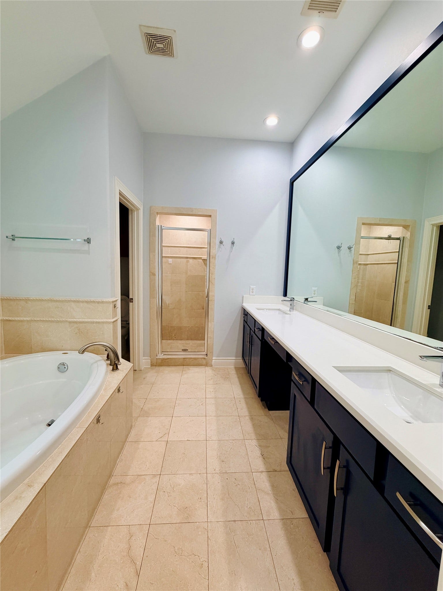 3526 Cline Street, Houston, TX 77020 This bright and spacious primary bathroom has recessed lighting, tile flooring, dual-vanity, tub, and a large walk-in shower with tile surround and glass enclosure, and a thoughtfully designed layout.