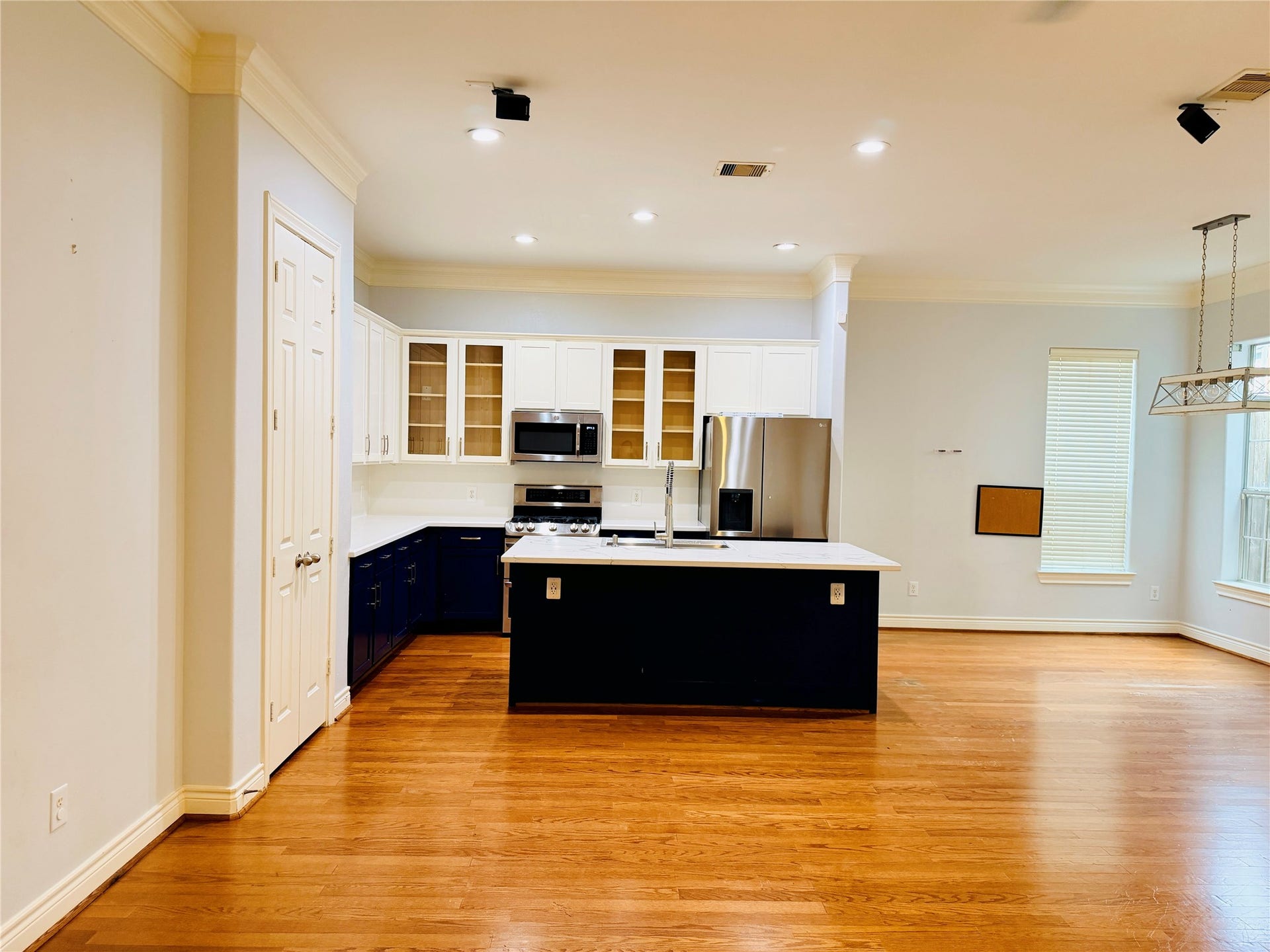 3526 Cline Street, Houston, TX 77020 Different angle of the kitchen features white cabinetry with glass-front upper cabinets, stainless steel appliances, a gas range, and abundant storage.
