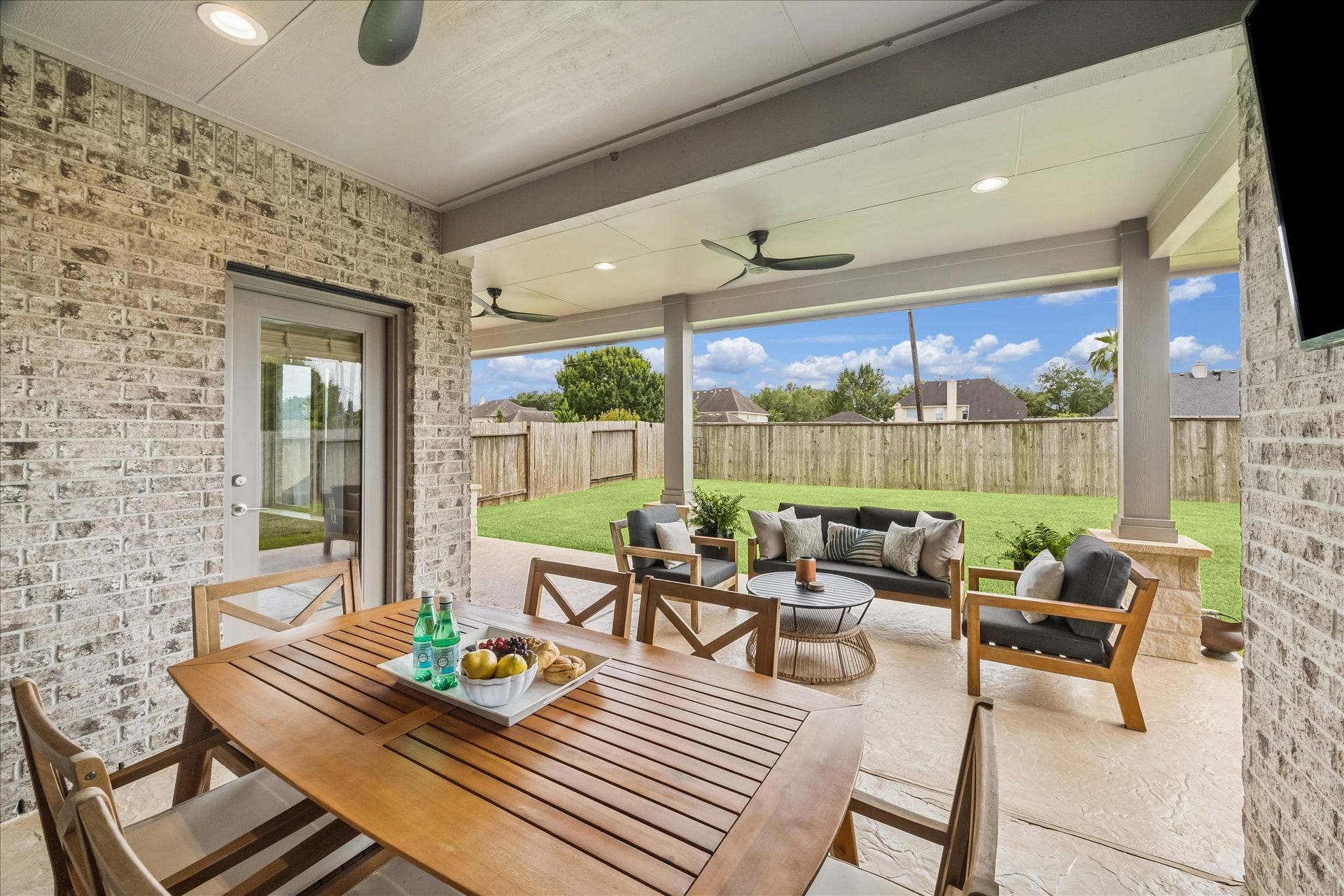 1520 Harvest Vine Court, Friendswood, TX 77546 Spacious custom back patio with dedicated dining, grilling, and seating areas, creating a true second living space outdoors.