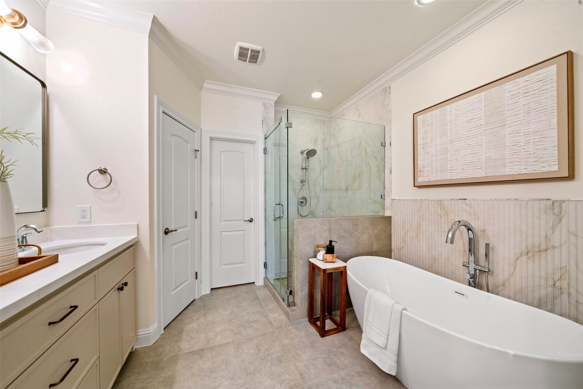 2627 Shady Woods Lane, Houston, TX 77008 The completely updated primary bath with soaking bath, separate shower, quartz counters, framed mirror and sleek fixtures and hardware.
