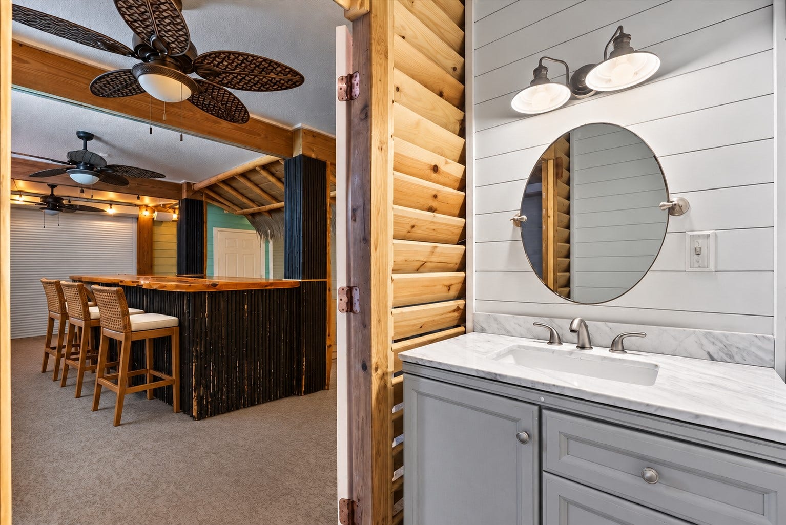 1331 EDWARDS DRIVE, Dickinson, TX 77539 CONVENIENT OUTDOOR BATHROOM LOCATED JUST OFF THE TIKI BAR, FEATURING A STONE COUNTERTOP, SHIPLAP ACCENT WALL, AND EASY PATIO ACCESS. **Virtually Staged.