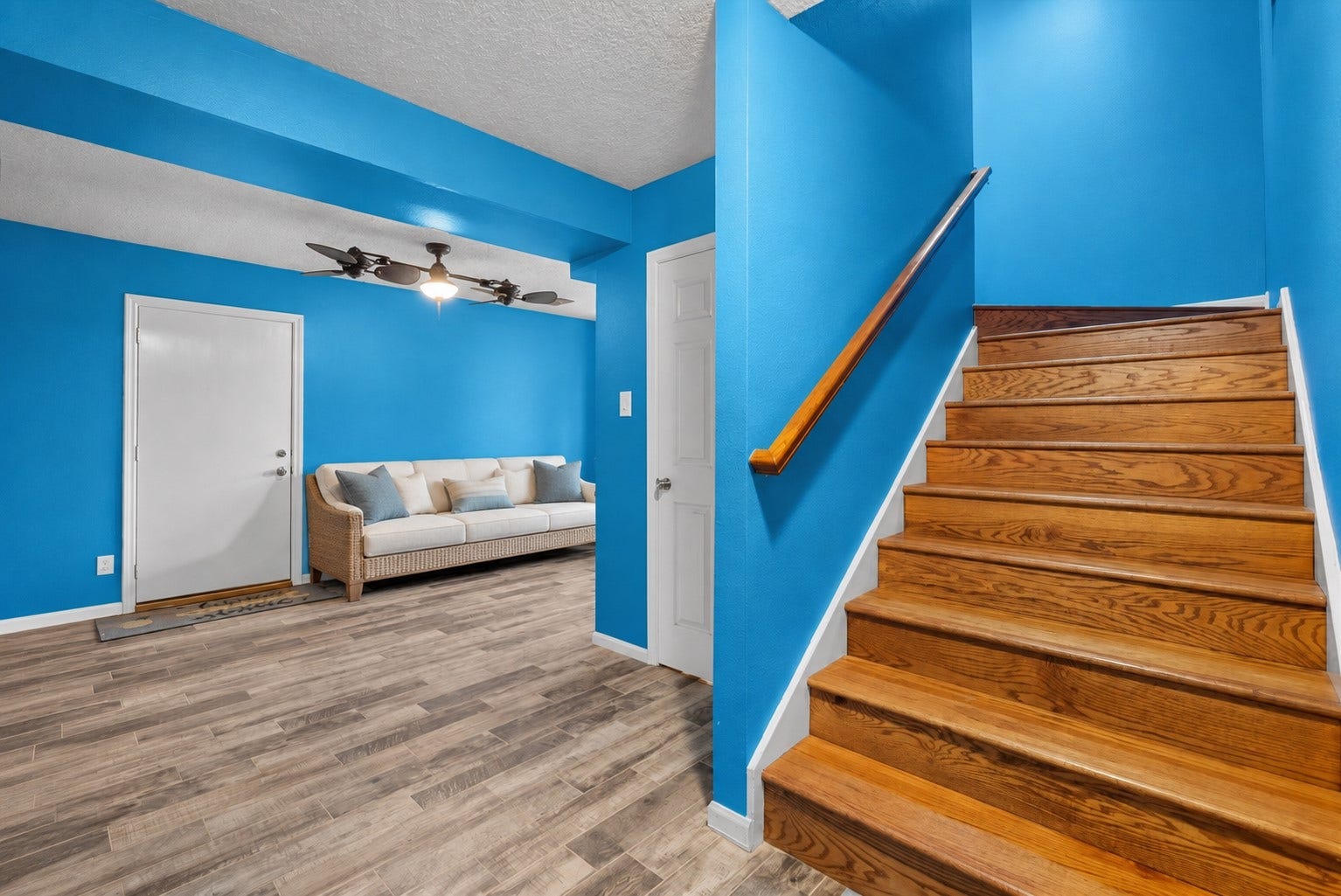 1331 EDWARDS DRIVE, Dickinson, TX 77539 A BRIGHT ENTRYWAY FEATURES WOOD-LOOK TILE FLOORING, VIBRANT COASTAL BLUE WALLS, AND A WARM WOOD STAIRCASE. THE OPEN LAYOUT CONNECTS TO A VERSATILE SITTING AREA WITH EASY ACCESS TO THE ADJACENT ROOMS.