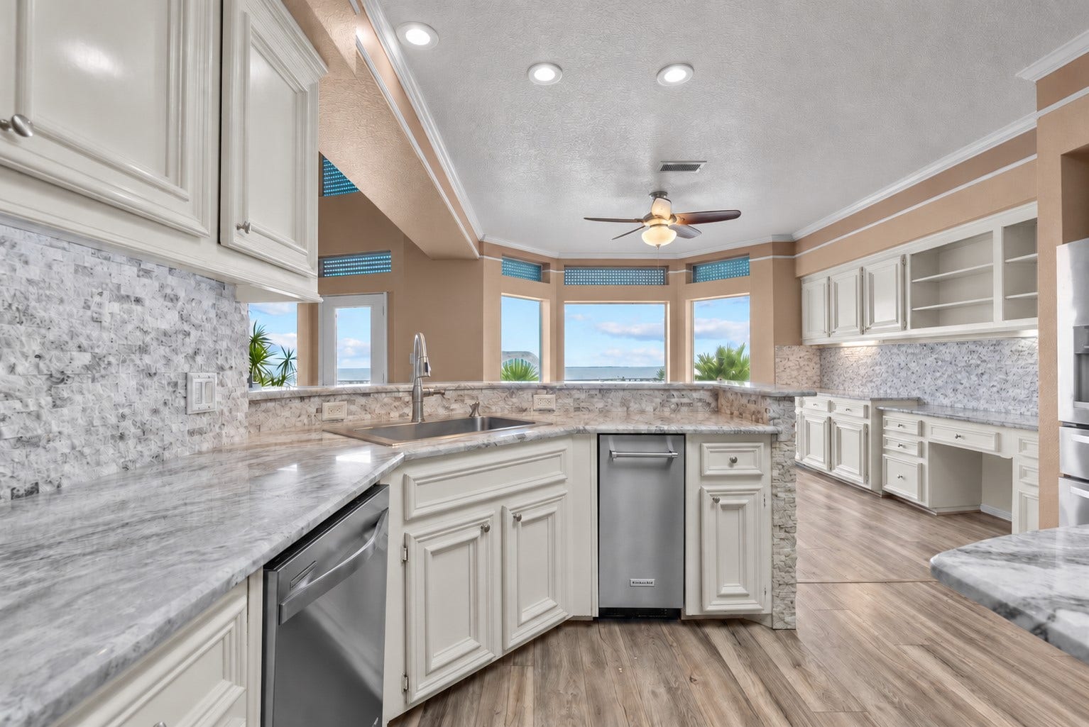 1331 EDWARDS DRIVE, Dickinson, TX 77539 EXPANSIVE KITCHEN WITH ABUNDANT CABINETRY, GENEROUS COUNTER SPACE, STAINLESS STEEL APPLIANCES, AND WATER VIEWS THROUGH MULTIPLE WINDOWS.