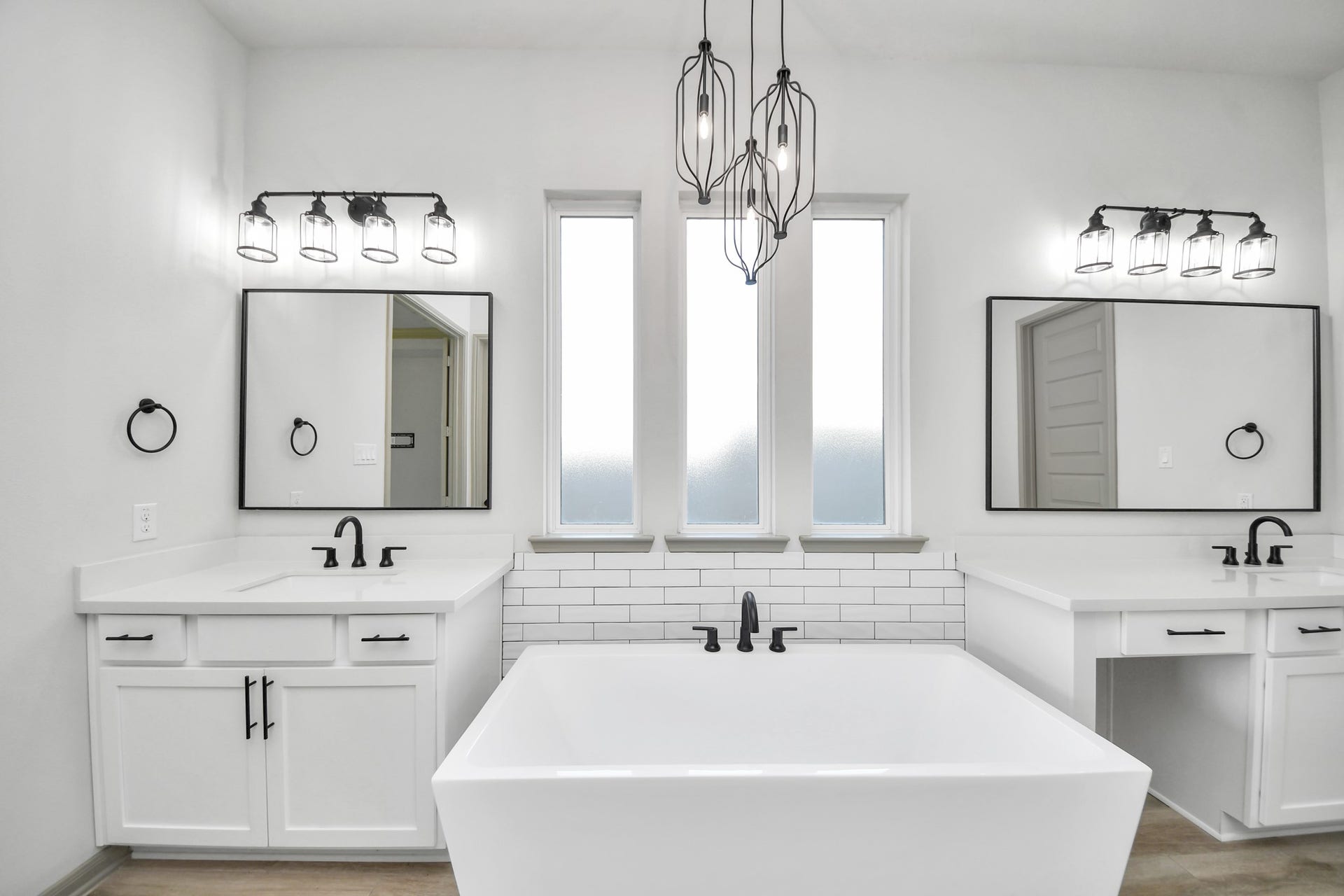1423 Hackberry Heights Drive, Richmond, TX 77406 Luxurious bathroom featuring a sleek freestanding tub, dual vanities with modern fixtures, and elegant lighting, creating a spa-like ambiance.
