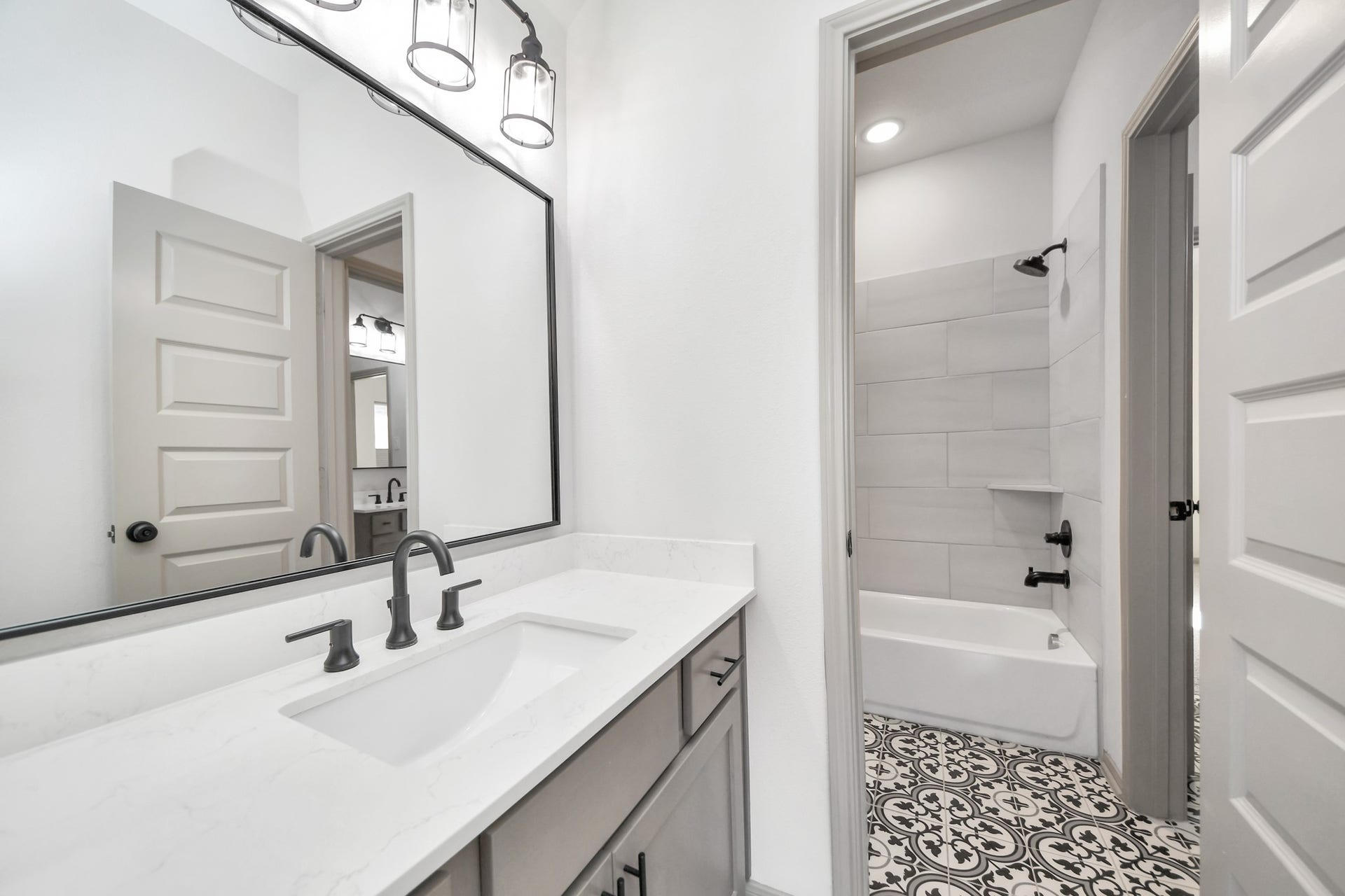 1423 Hackberry Heights Drive, Richmond, TX 77406 Stylish bathroom featuring a sleek double vanity with modern fixtures, a large framed mirror, and a chic tub with contemporary tile accents.