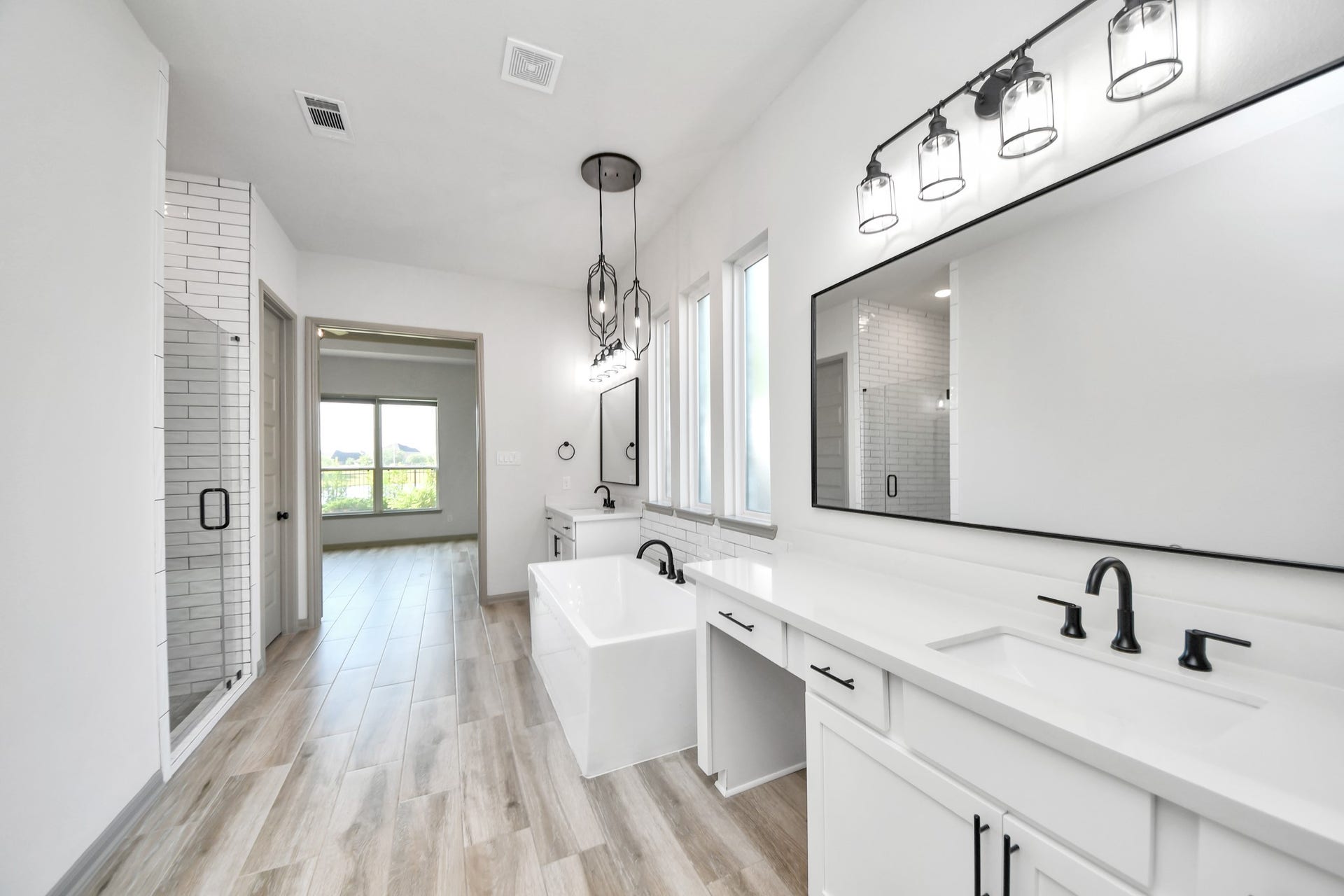 1423 Hackberry Heights Drive, Richmond, TX 77406 Luxurious bathroom featuring a spacious double vanity with modern fixtures, a sleek freestanding tub, and a stylish glass-enclosed shower.