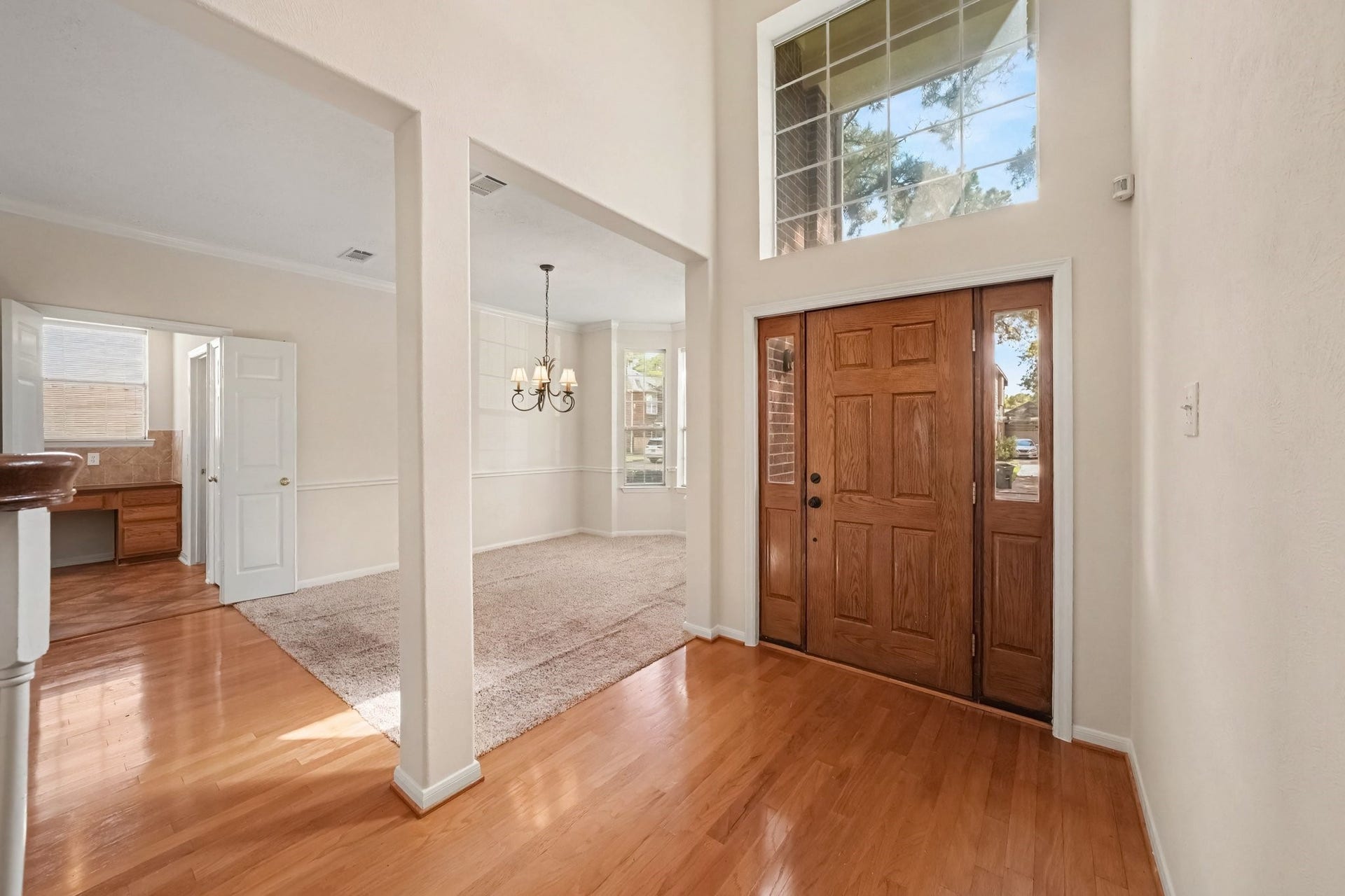 17510 Tall Maple Court, Houston, TX 77095 A second view of the impressive two-story entry, featuring beautiful wood flooring, soaring ceilings, and a large picture window above the front door that fills the space with natural light. The formal dining room sits just off the entry, with convenient access to the kitchen.