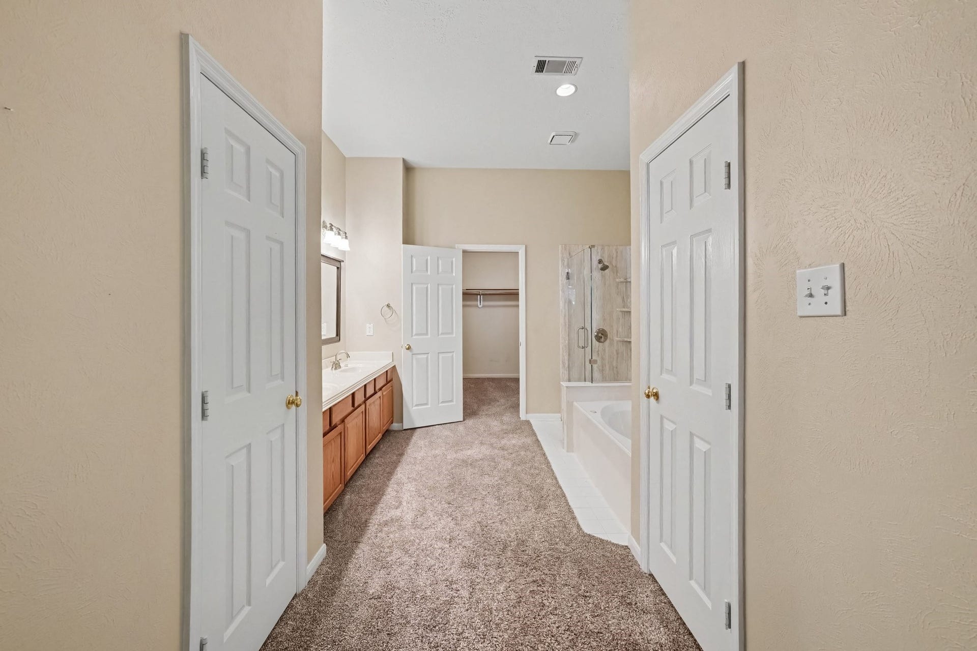 17510 Tall Maple Court, Houston, TX 77095 The primary en-suite bathroom offers a double-sink vanity with generous counter space, a soaking tub, separate glass-enclosed shower, and a large walk-in closet, providing plenty of room for everyday comfort and convenience.