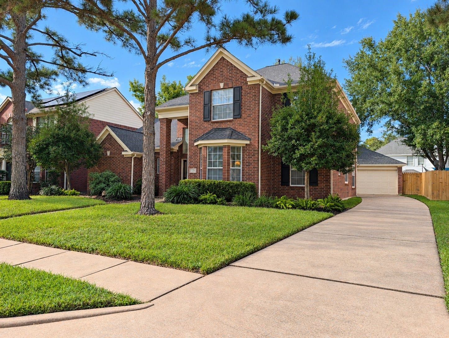 17510 Tall Maple Court, Houston, TX 77095 Classic brick exterior framed by mature trees and well-maintained landscaping, with a long driveway leading to the detached garage.