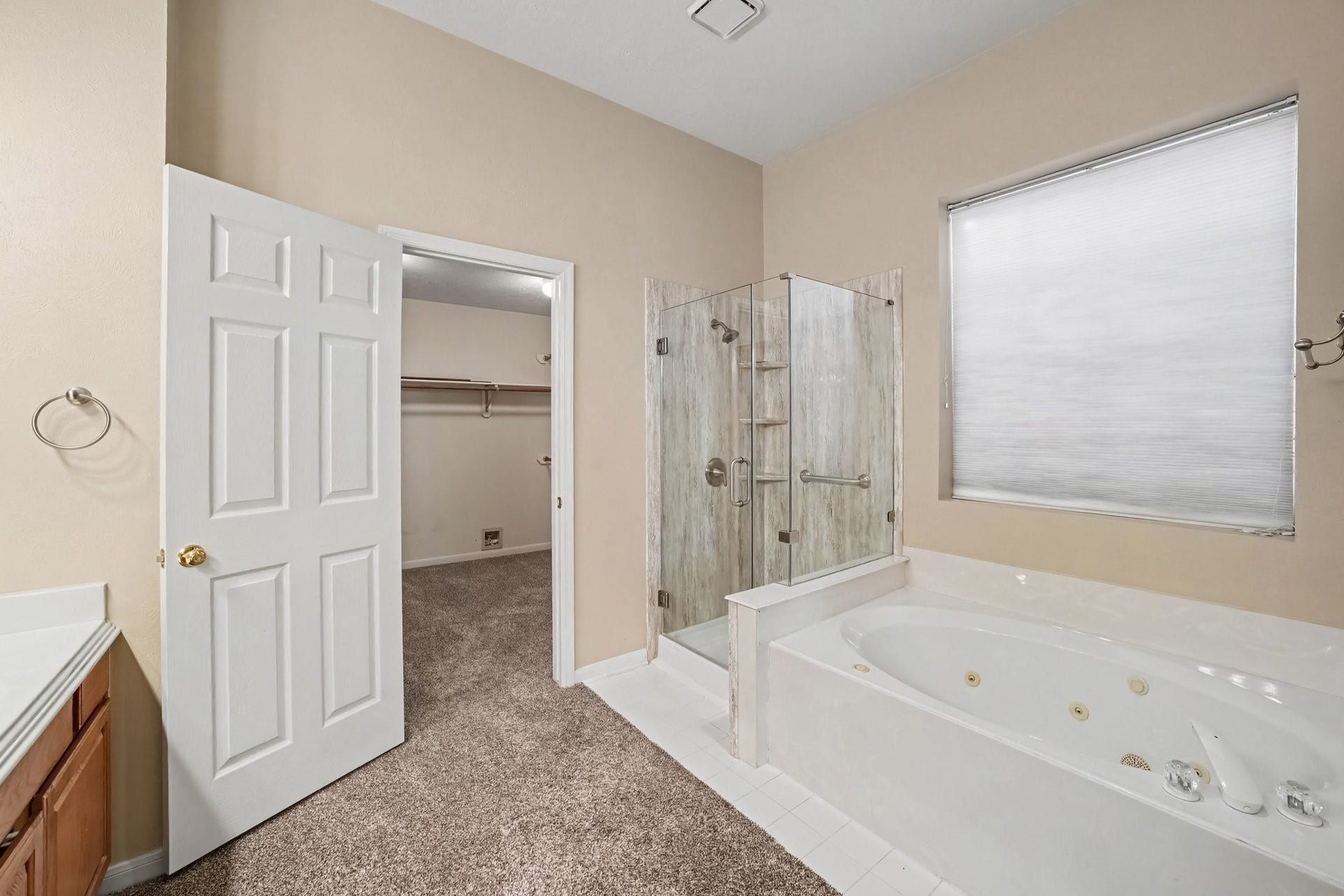 17510 Tall Maple Court, Houston, TX 77095 The primary bathroom features a relaxing jetted soaking tub and a separate frameless glass shower with beautiful tile surround. A large walk-in closet offers plenty of storage, while the window brings in natural light.