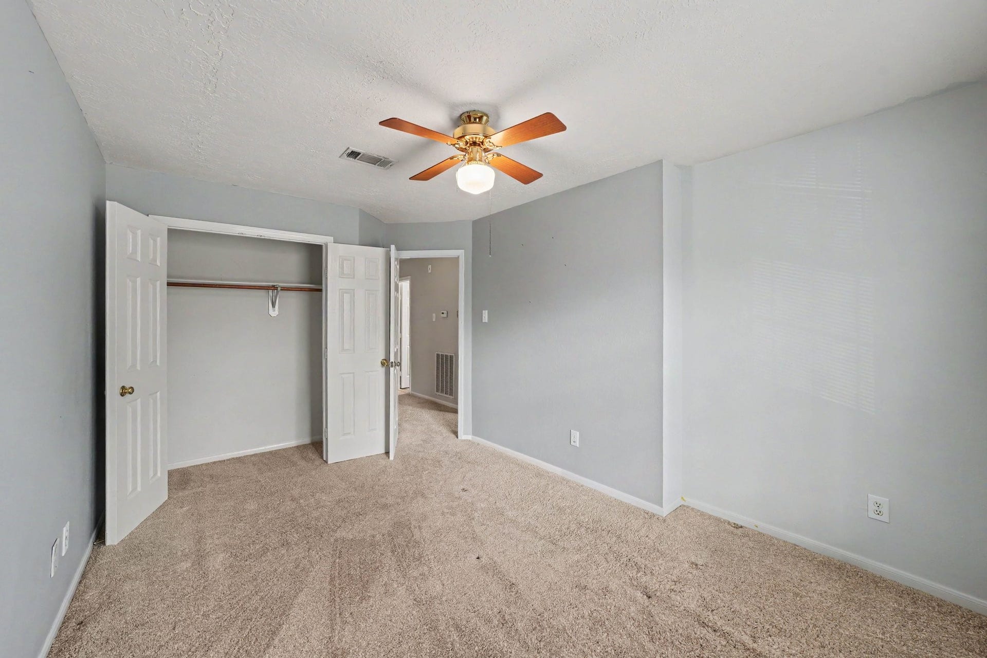 17510 Tall Maple Court, Houston, TX 77095 A second view of the upstairs secondary bedroom highlights the generous room size and closet space with double doors, and soft gray walls.