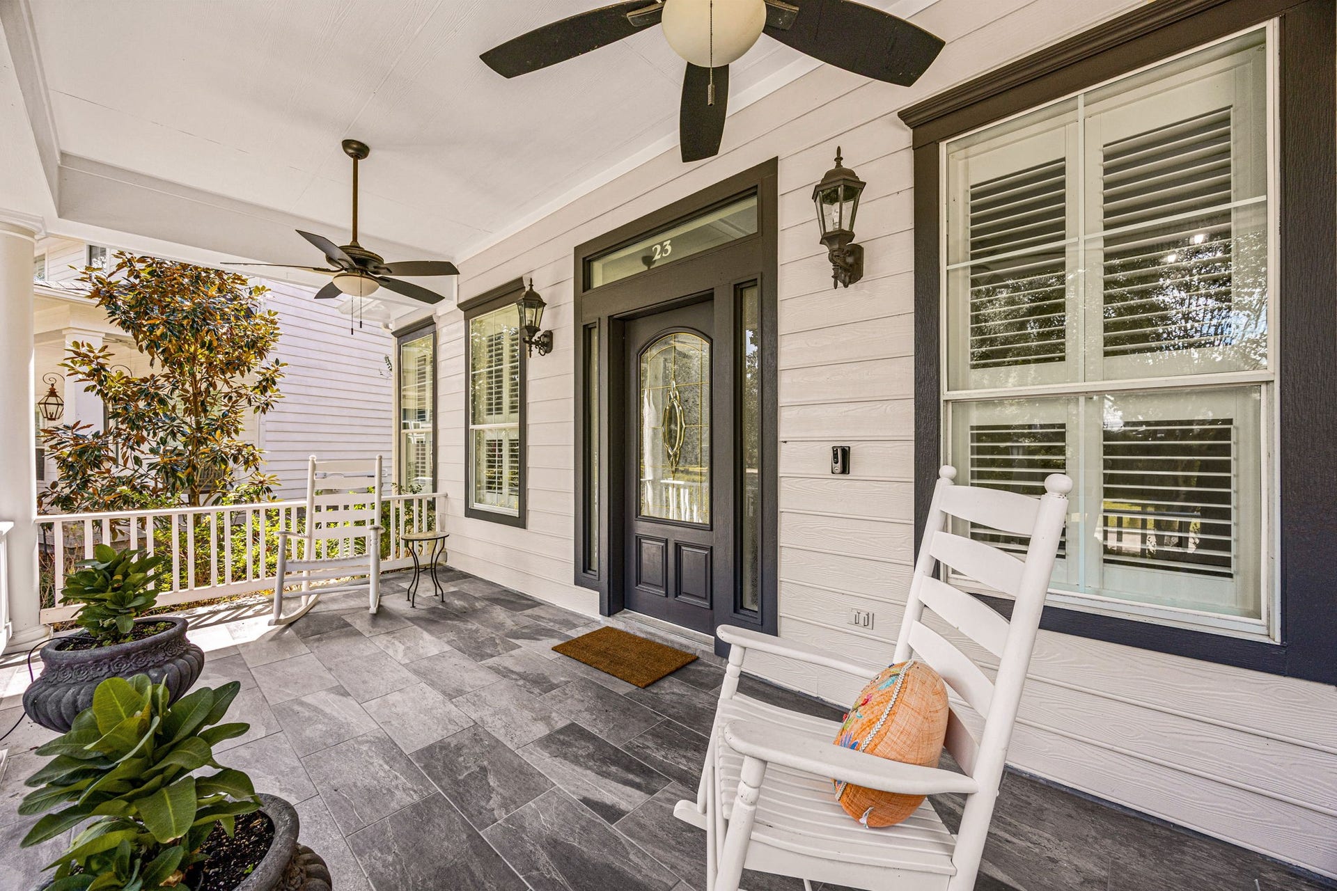 23 Pipers Meadow Street, The Woodlands, TX 77382 Relax and unwind on the expansive, deep front porch featuring premium slate-style tile flooring, dual ceiling fans, elegant carriage lighting, and beautiful plantation shutters.