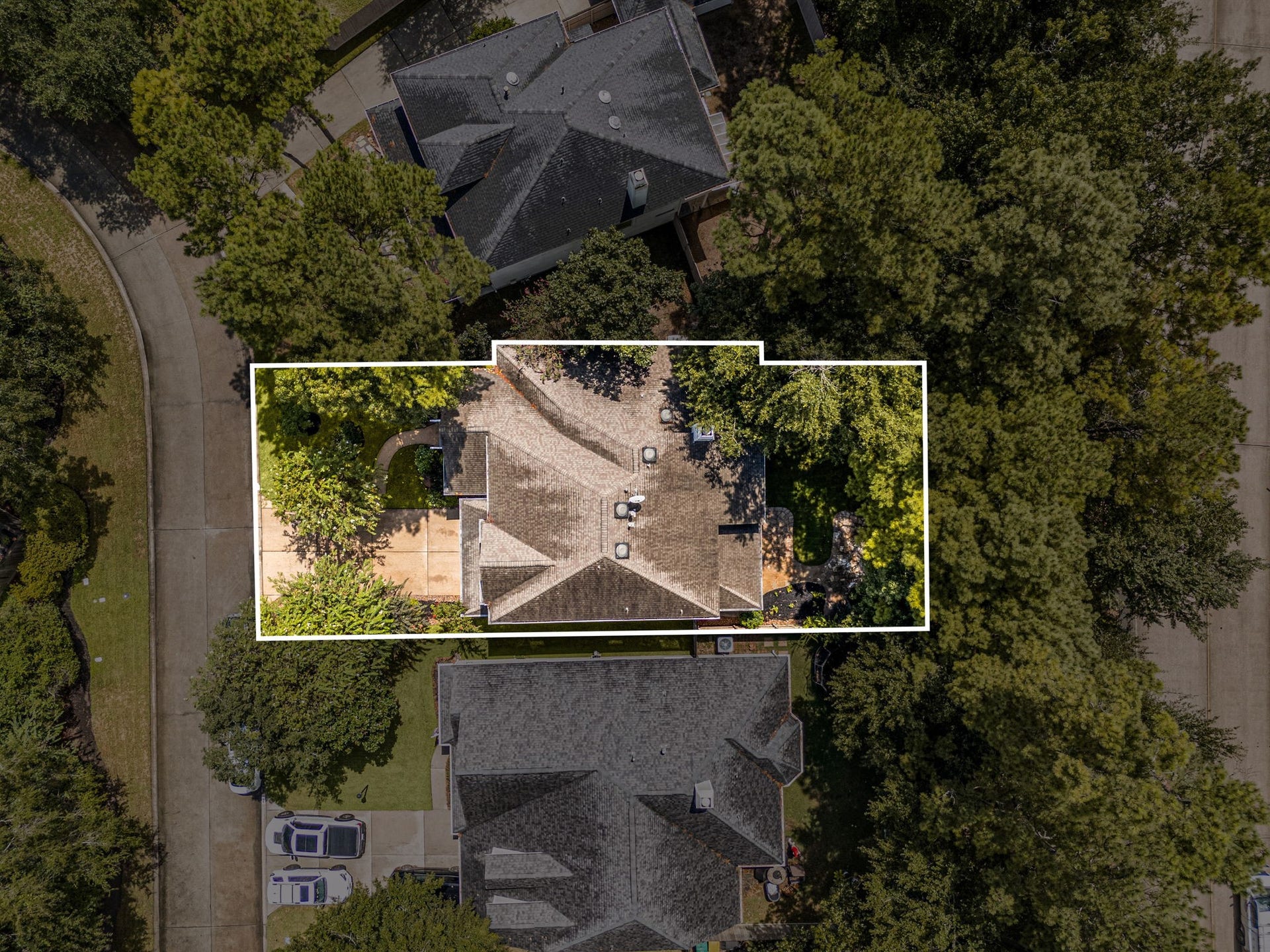 23 Pipers Meadow Street, The Woodlands, TX 77382 Aerial view with property boundaries outlined, showcasing the large homesite surrounded by mature trees and offering a private, spacious setting.