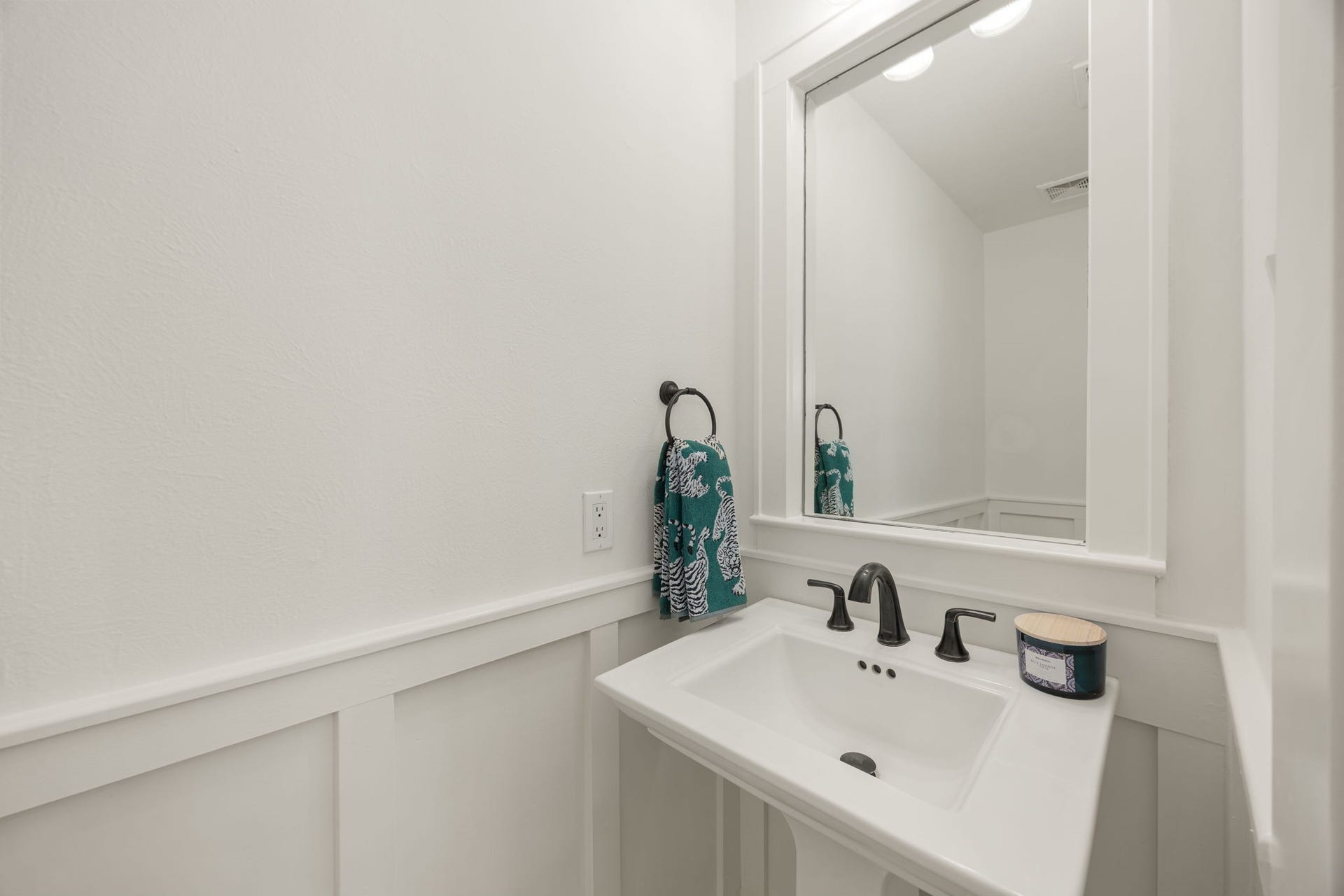 23 Pipers Meadow Street, The Woodlands, TX 77382 This crisp and neutral powder room features a pedestal sink and framed mirror - bright, open, and inviting for your guests.