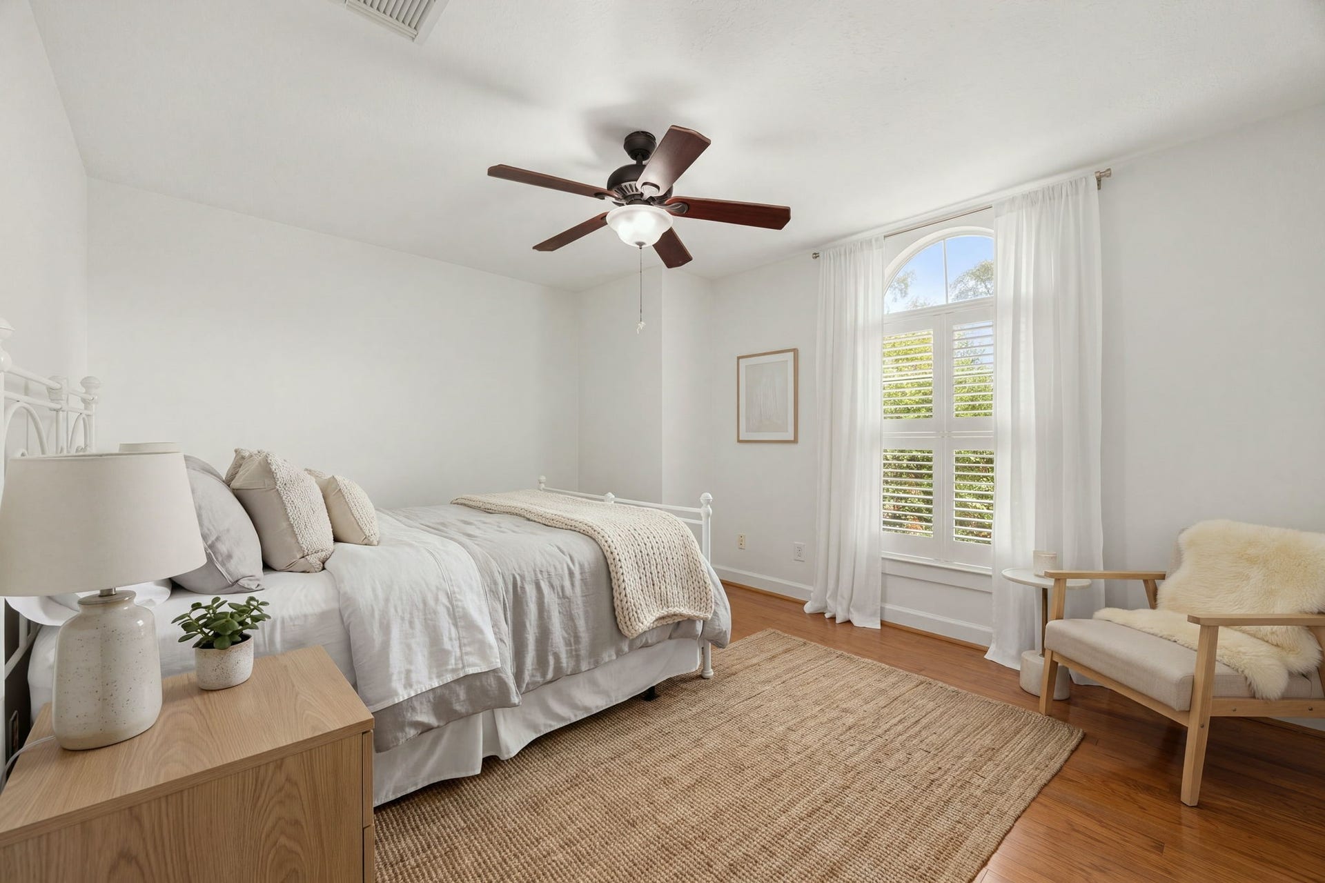 23 Pipers Meadow Street, The Woodlands, TX 77382 Another generously sized secondary bedroom boasting a striking arched accent window with custom plantation shutters, rich hardwood floors, and a cooling ceiling fan. *Virtually Staged