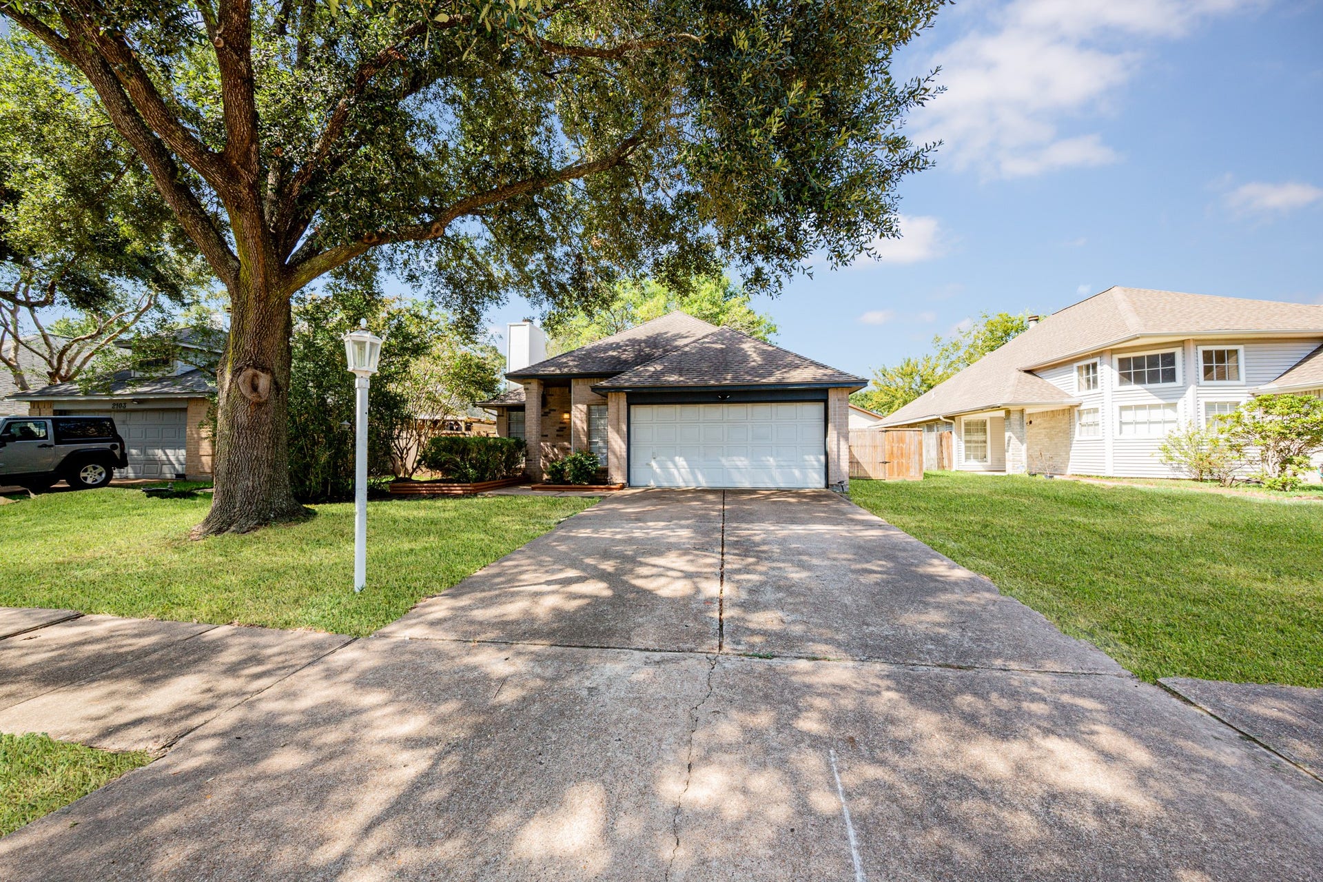 2107 Foundary Drive, Katy, TX 77493 Beautiful mature trees provide shade and curb appeal, complementing the home's established landscaping and spacious front lawn.
