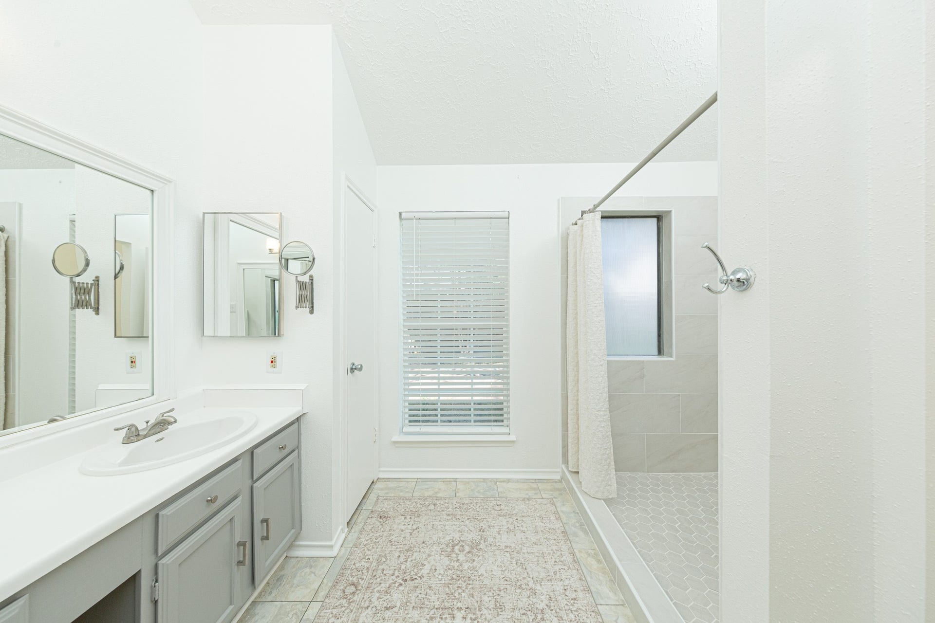 2107 Foundary Drive, Katy, TX 77493 The primary bathroom offers an expansive vanity, tile flooring, natural light, and a beautifully updated walk-in shower.