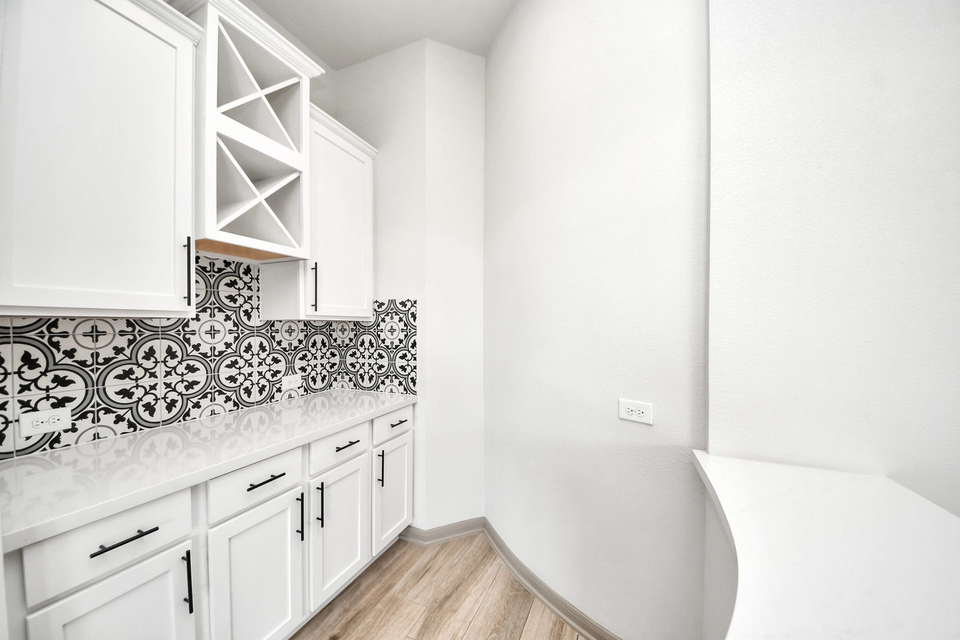 1423 Hackberry Heights Drive, Richmond, TX 77406 Bright and stylish dry bar featuring white cabinetry with sleek black hardware.