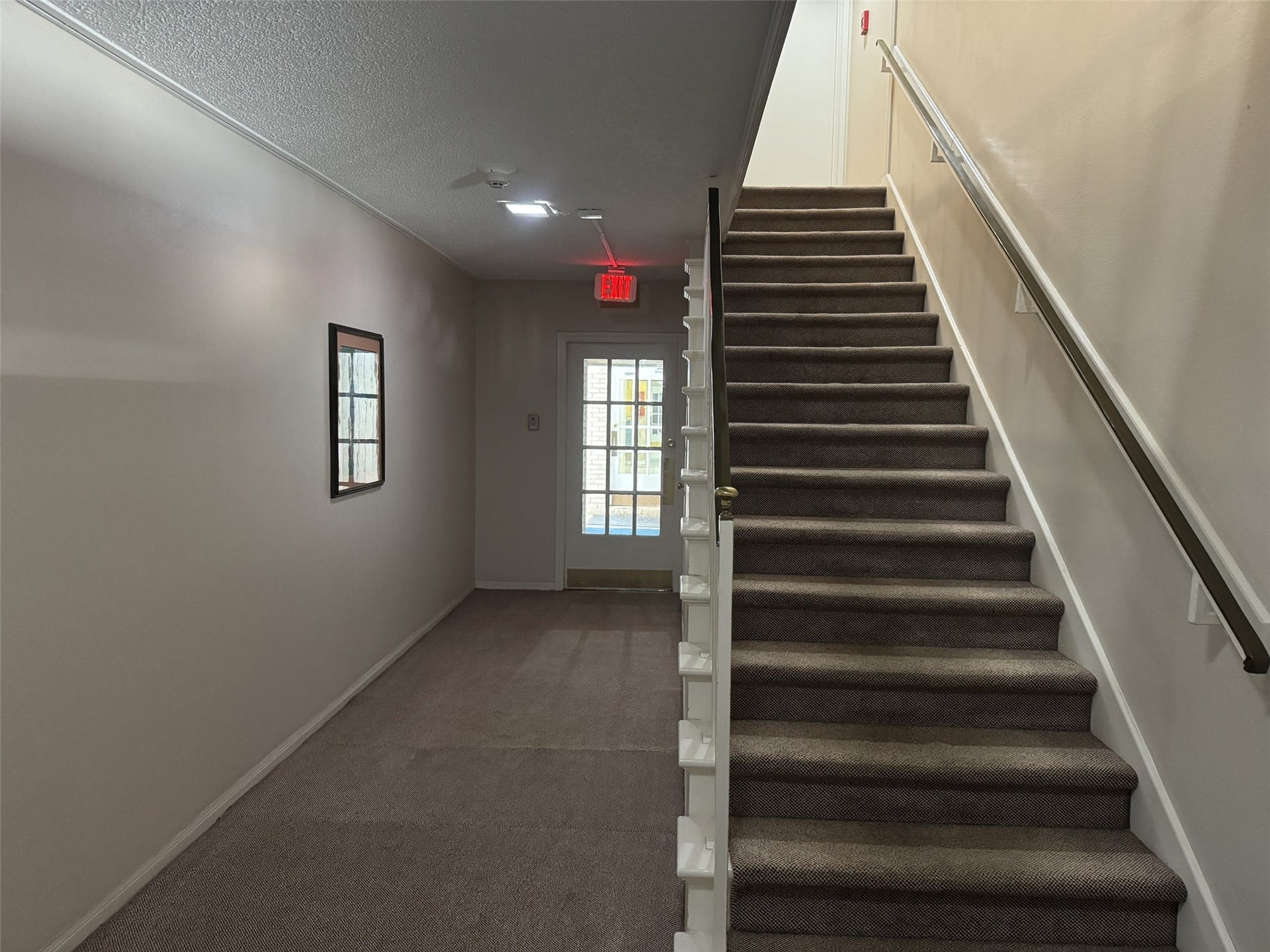 2600 Bellefontaine Street, #A18, Houston, TX 77025 Standing in doorway of A18 looking at central laundry through doorway on the left and stairway to inside laundry on the 2nd floor